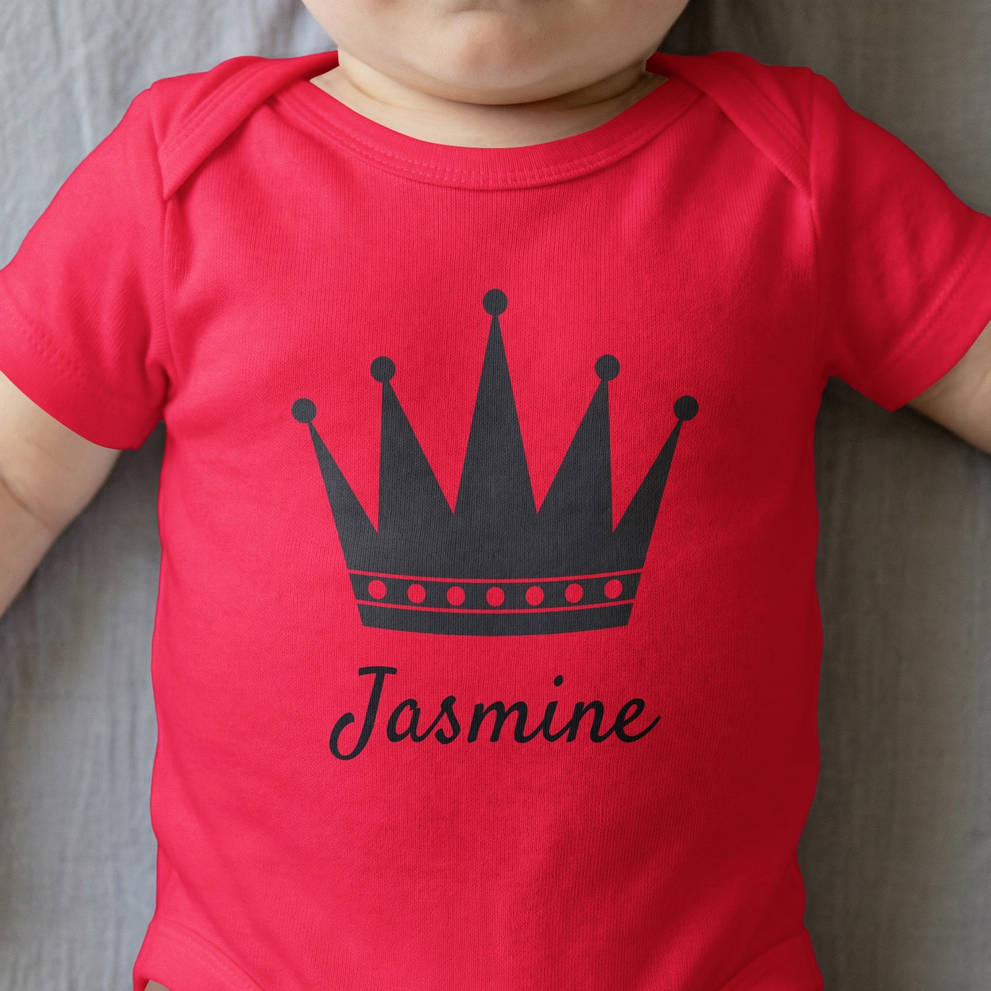 Red baby onesie with a dark crown and "Jasmine" text.