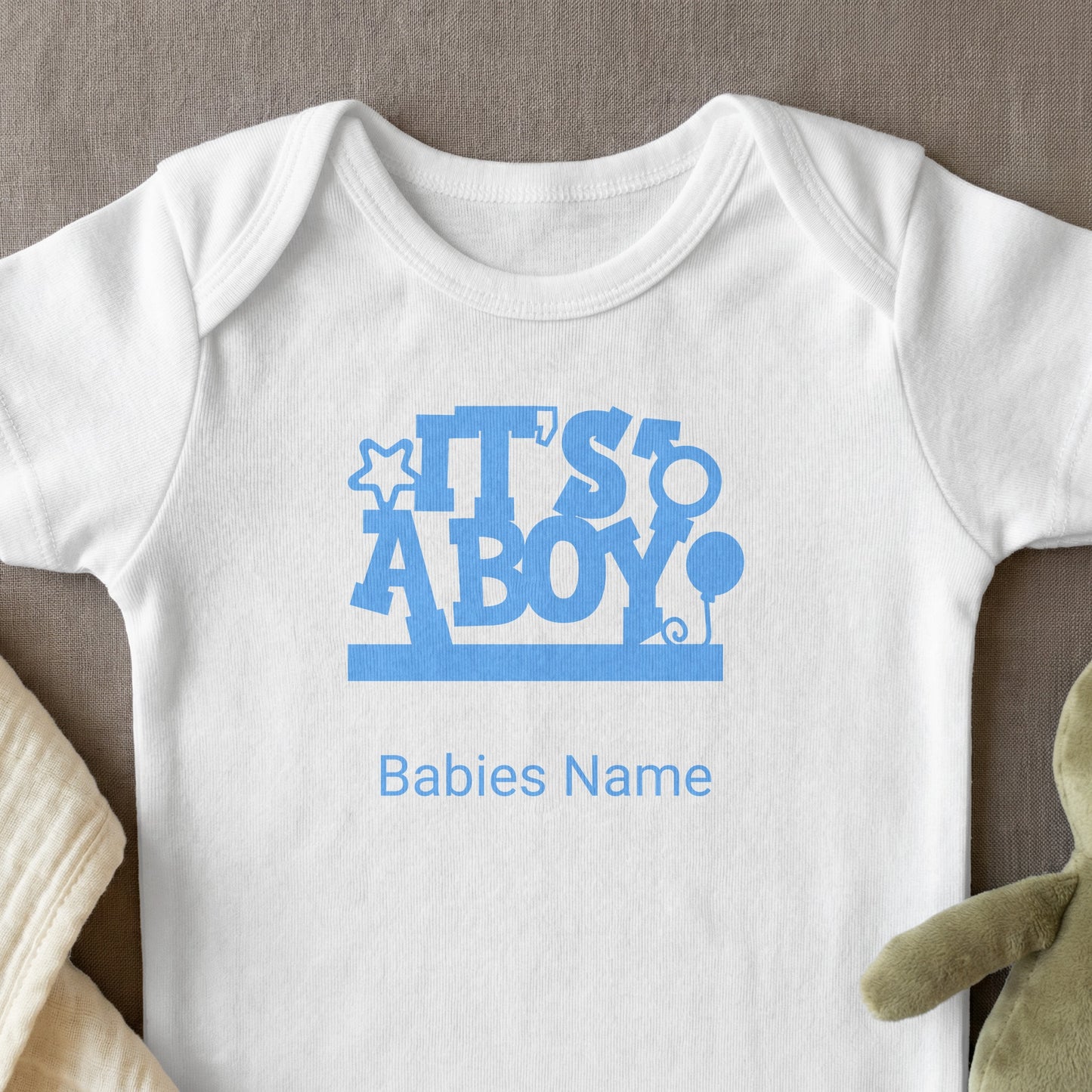White baby onesie with blue "It's a Boy!" text and "Babies Name" placeholder.