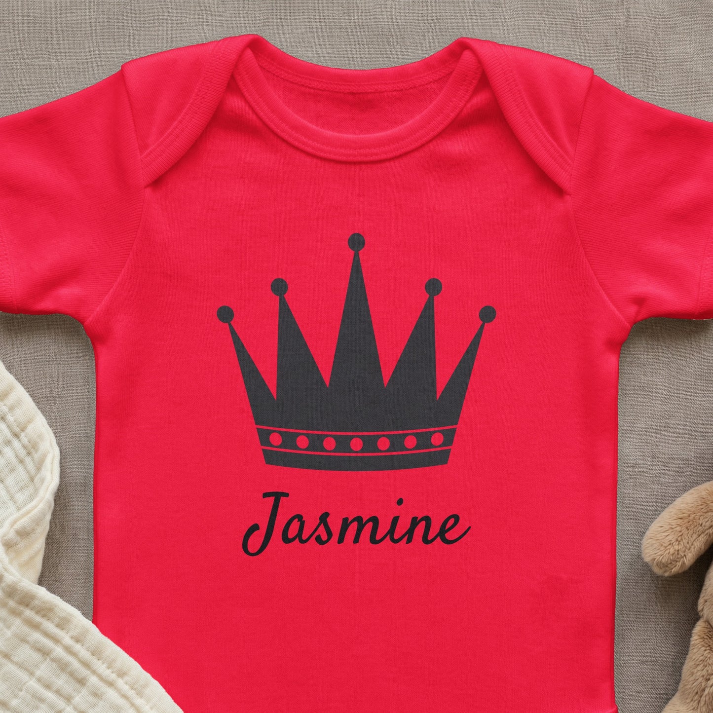 Red baby onesie with a black crown and "Jasmine" text.