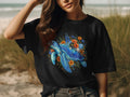 Black t-shirt with a blue sea turtle design surrounded by colorful flowers.