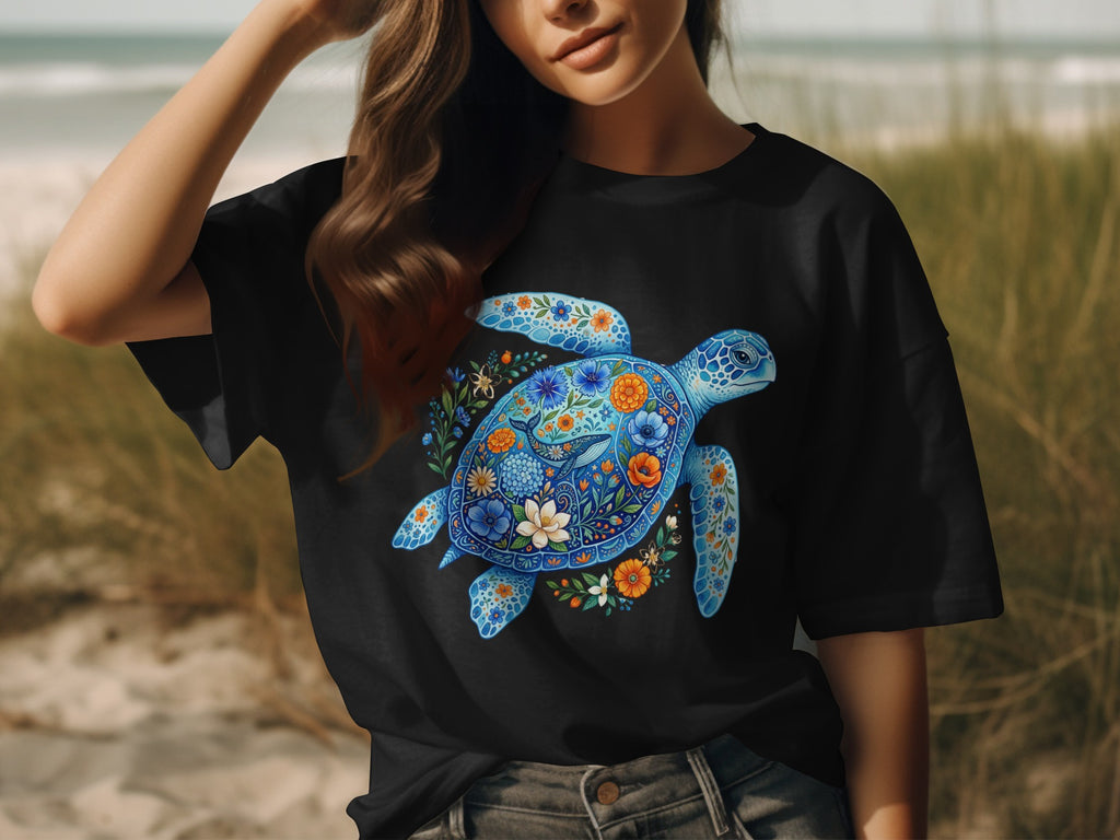 Black t-shirt with a blue sea turtle decorated with colorful floral patterns.