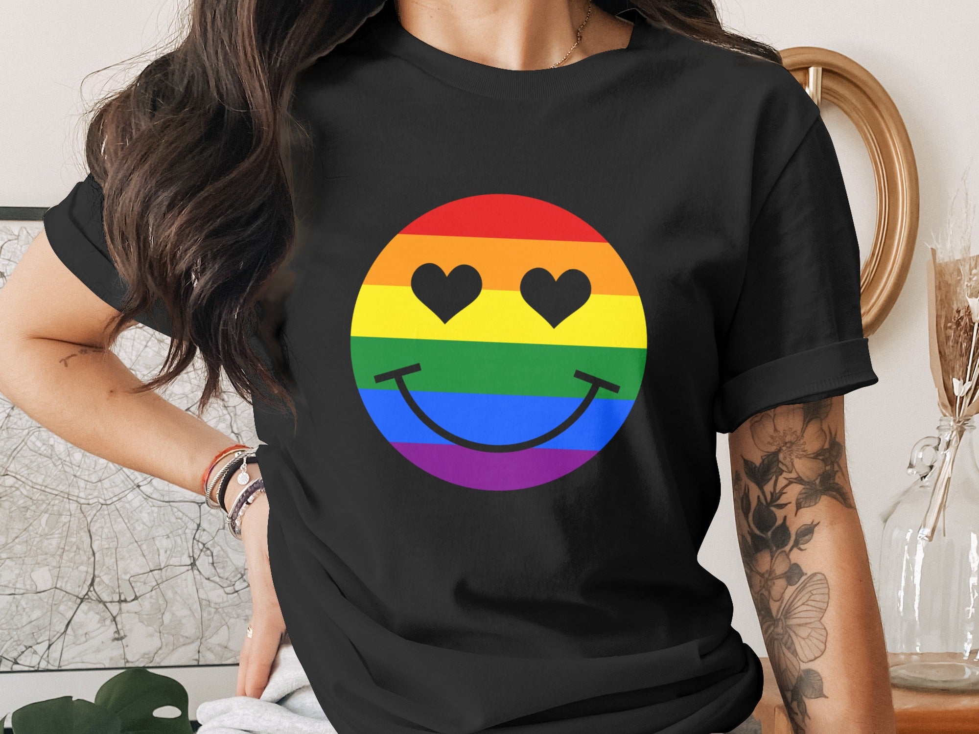 Black t-shirt with rainbow smiley face featuring heart eyes and stripes.