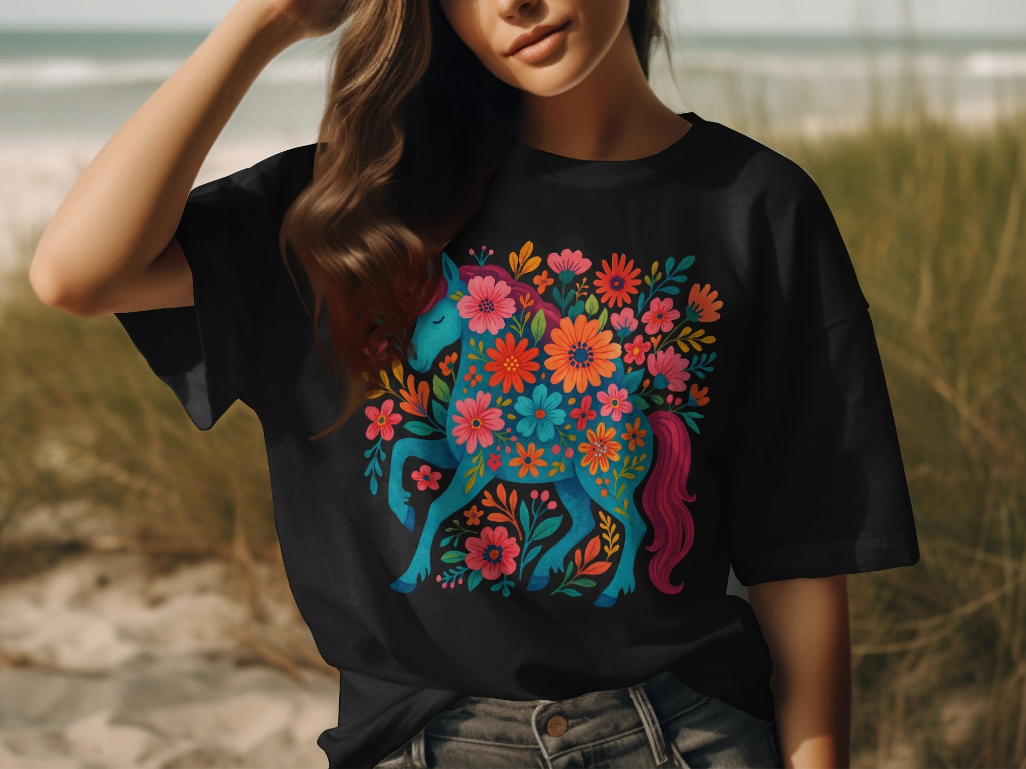 Black t-shirt with a blue unicorn surrounded by colorful flowers and foliage.