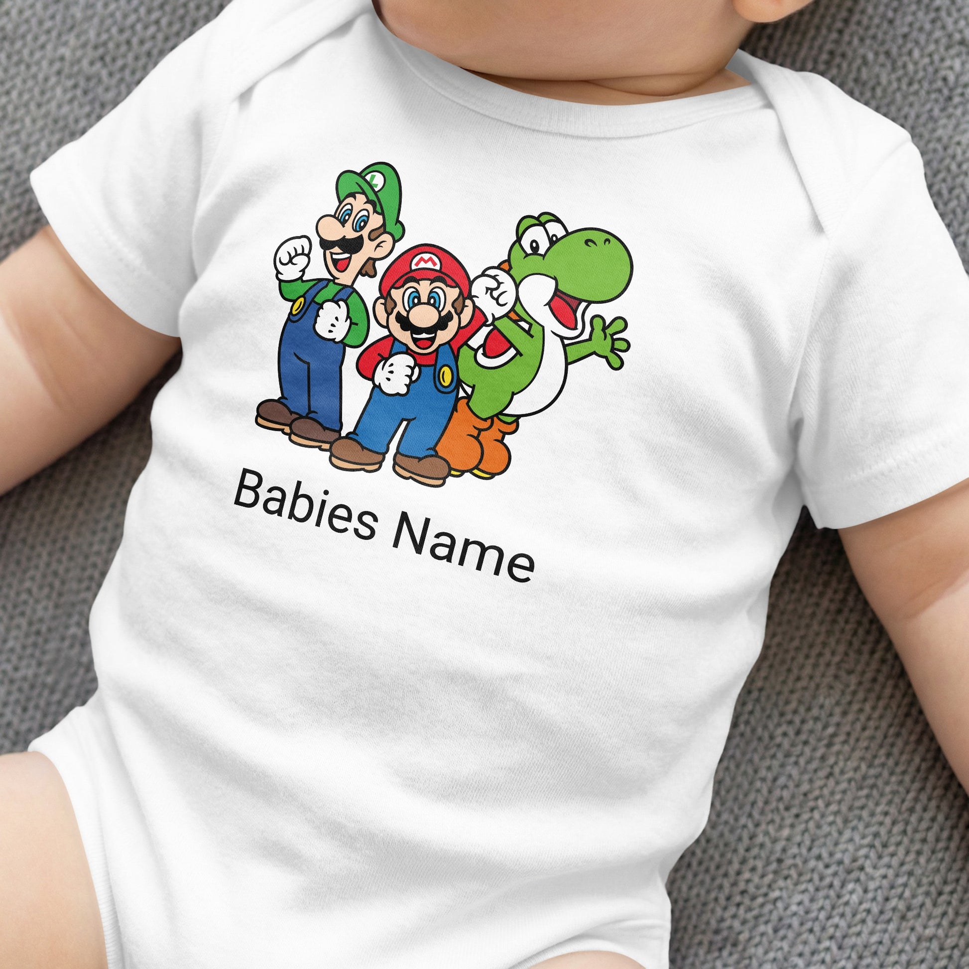 Mario, Luigi, and Yoshi characters on a white baby onesie with "Babies Name" text.