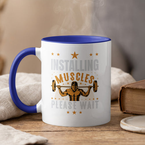 White mug with blue rim: "Installing Muscles Please Wait" text and weightlifter graphic.