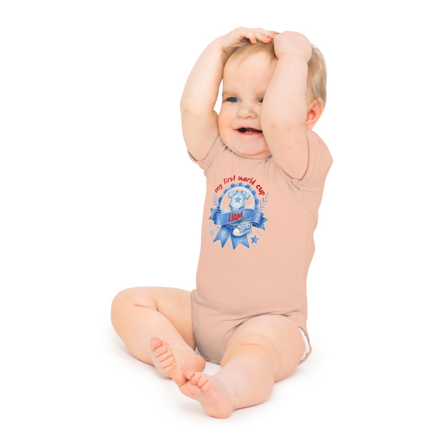 Baby in a peach onesie with "my first world cup" text and a soccer ball graphic.