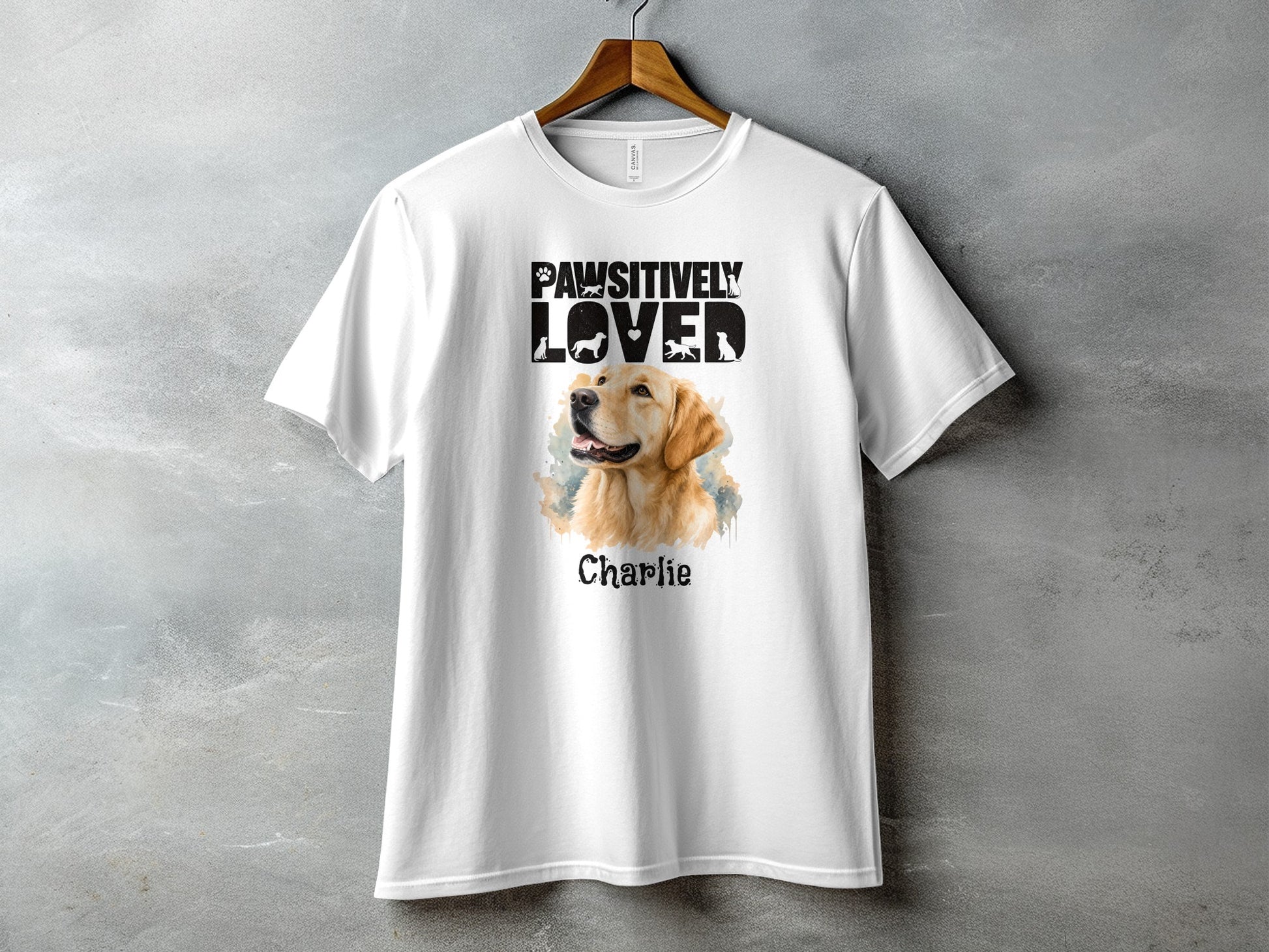 White t-shirt featuring a Golden Retriever portrait with "Pawsitively Loved" text and "Charlie".