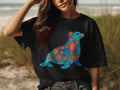 Black t-shirt with a blue seal design adorned with colorful floral patterns.