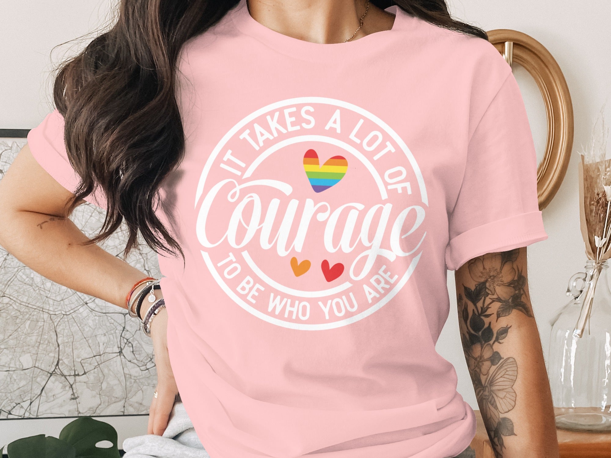Pink t-shirt with white text "It Takes a Lot of Courage To Be Who You Are" and rainbow heart.