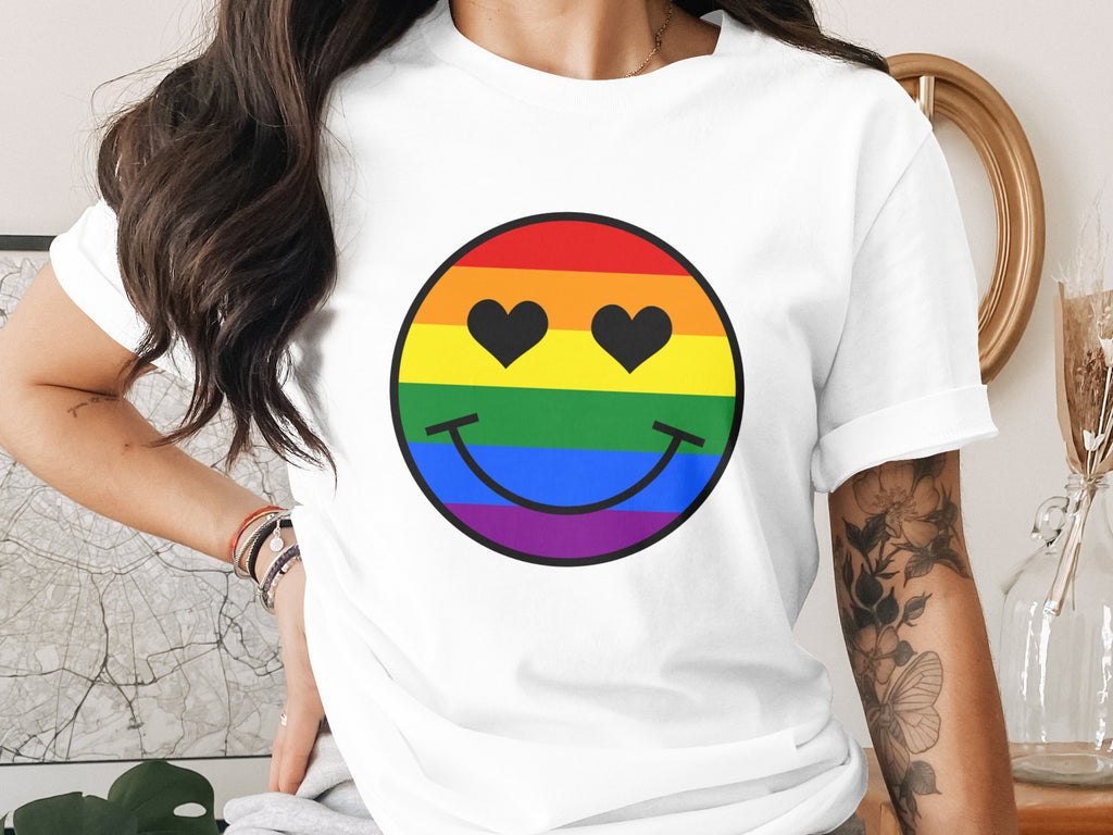 White t-shirt with rainbow smiley face featuring black heart eyes.