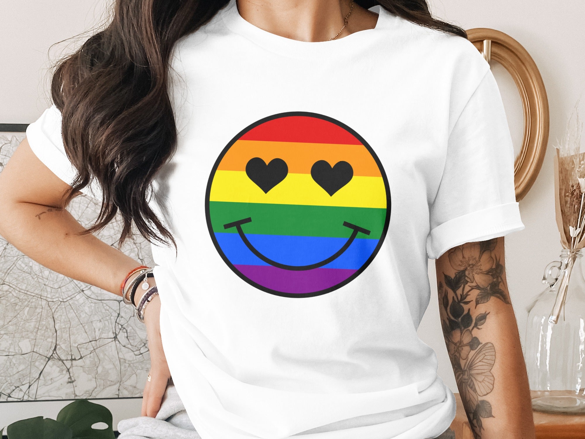 White t-shirt with rainbow smiley face featuring black heart eyes.