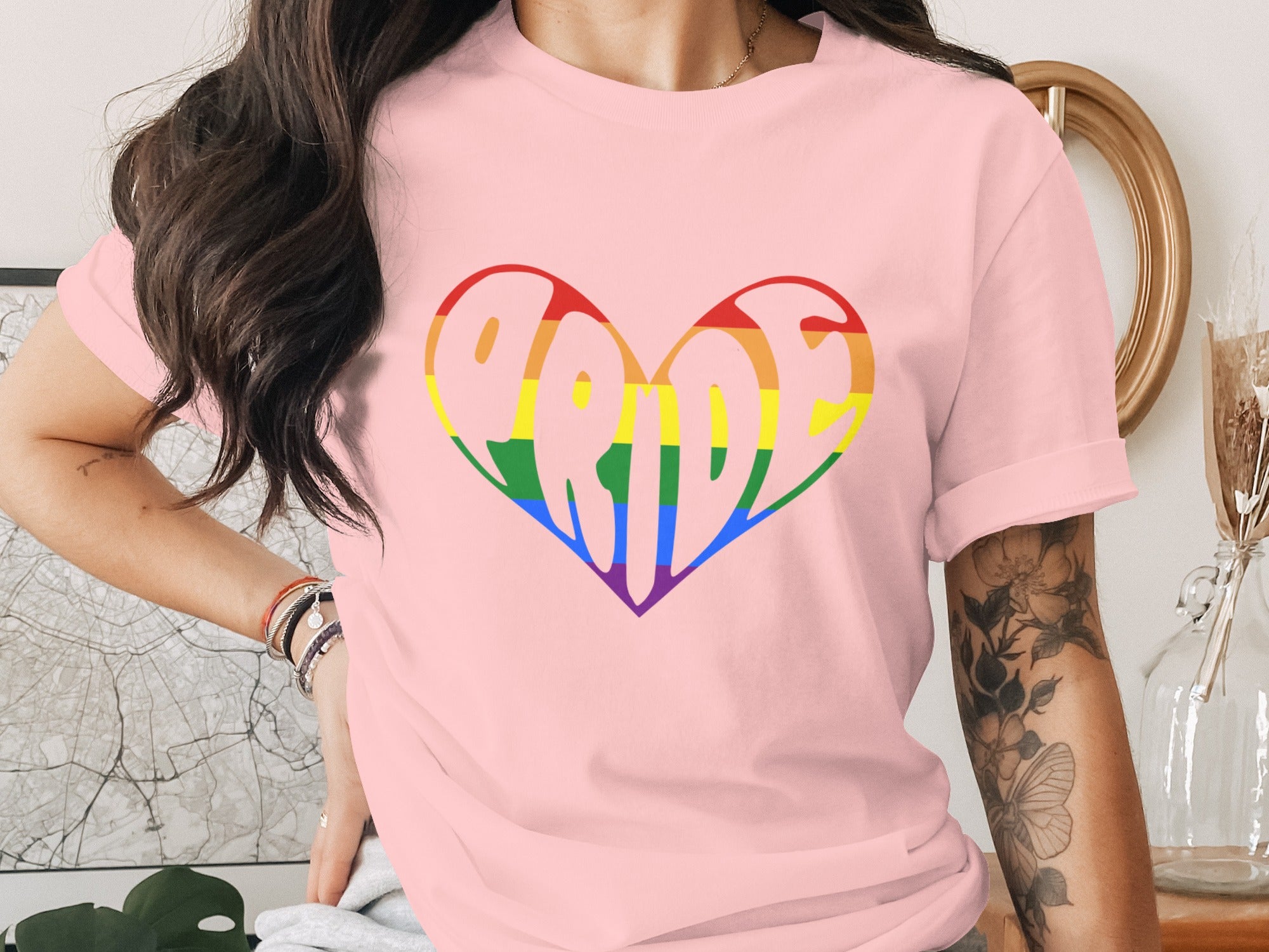 Pink t-shirt with a rainbow heart graphic spelling out "PRIDE".