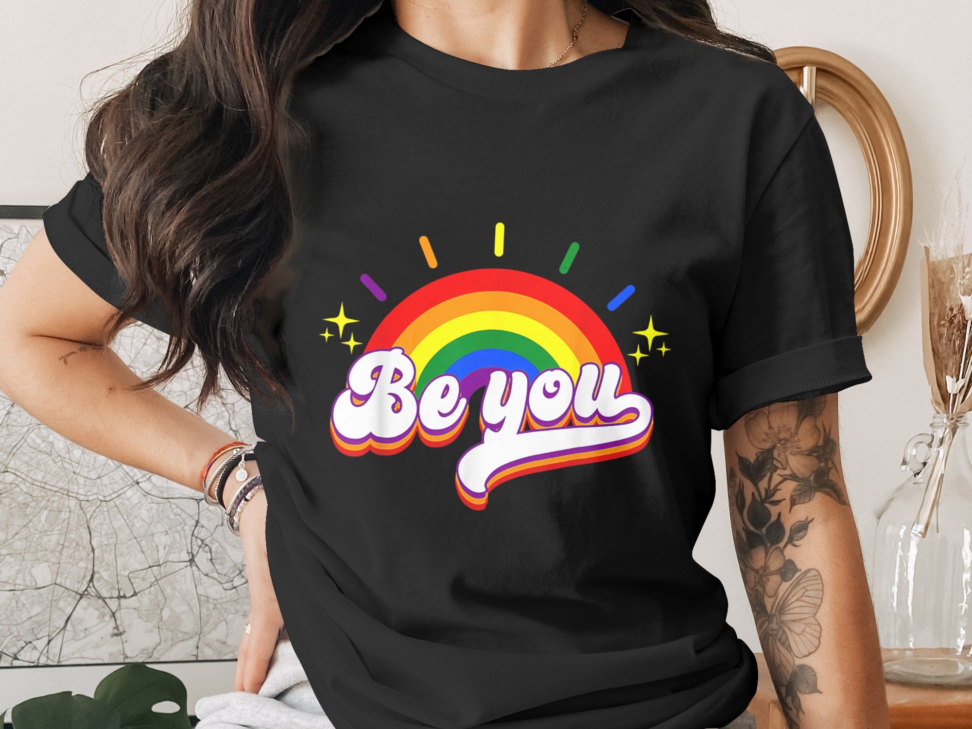 Black t-shirt with rainbow arc graphic and "Be you" text.