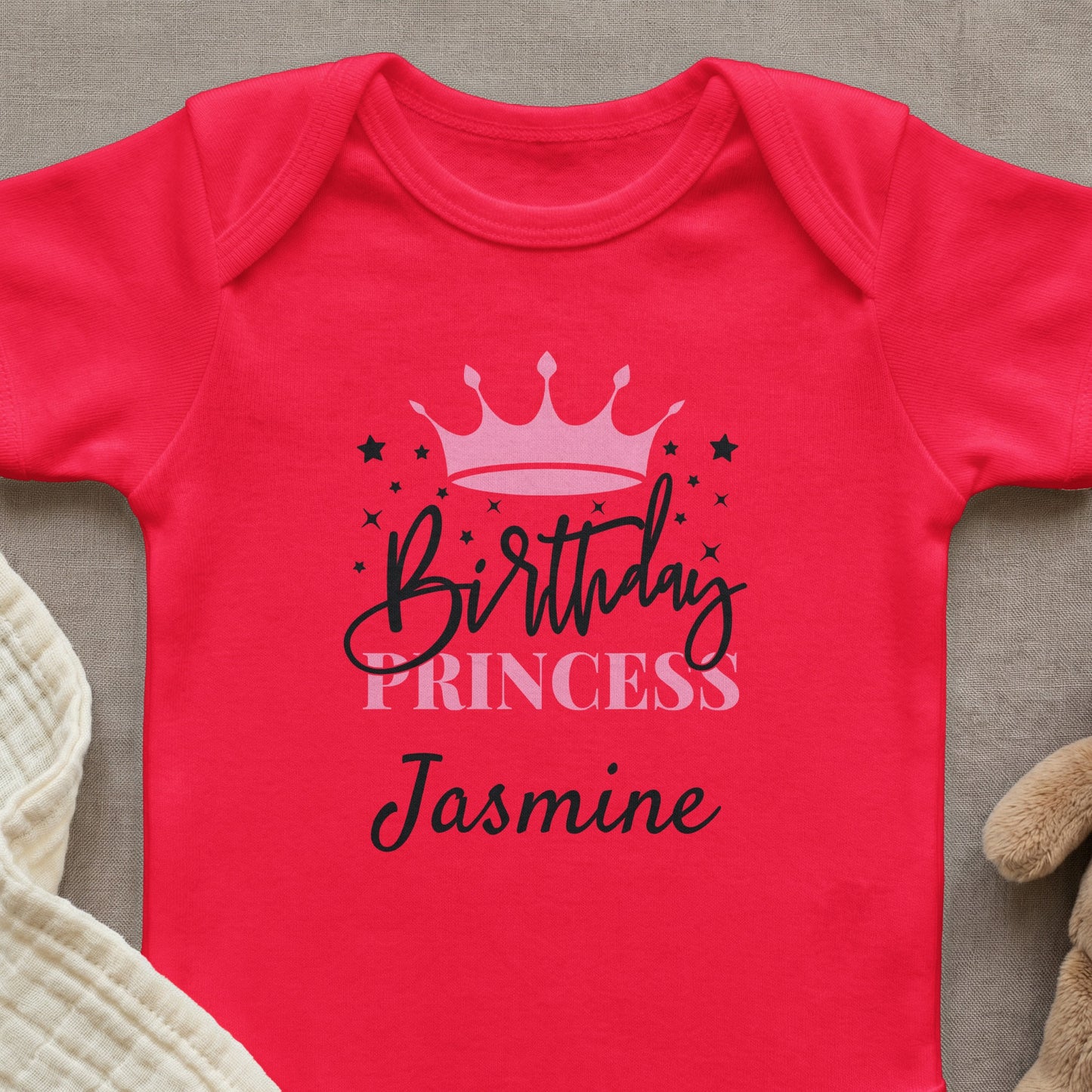 Red baby onesie with "Birthday Princess Jasmine" text and crown graphic.