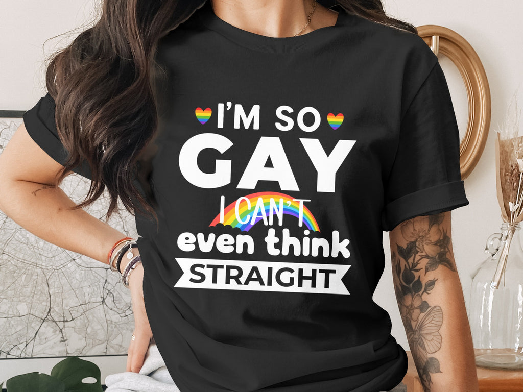 Black t-shirt with "I'M SO GAY I CAN'T even think STRAIGHT" text and rainbow heart accents.