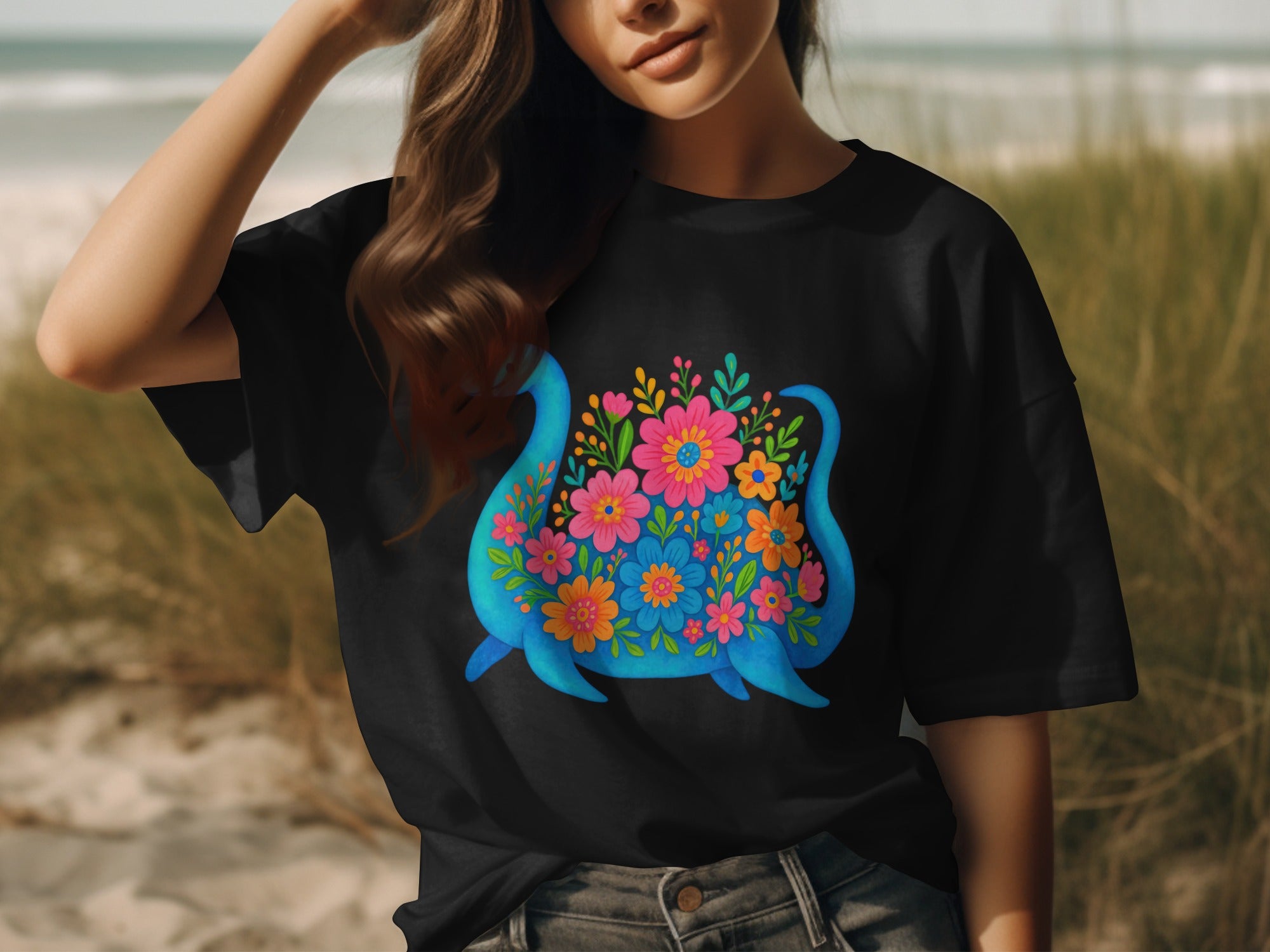 Black t-shirt with a blue creature decorated with colorful flowers.
