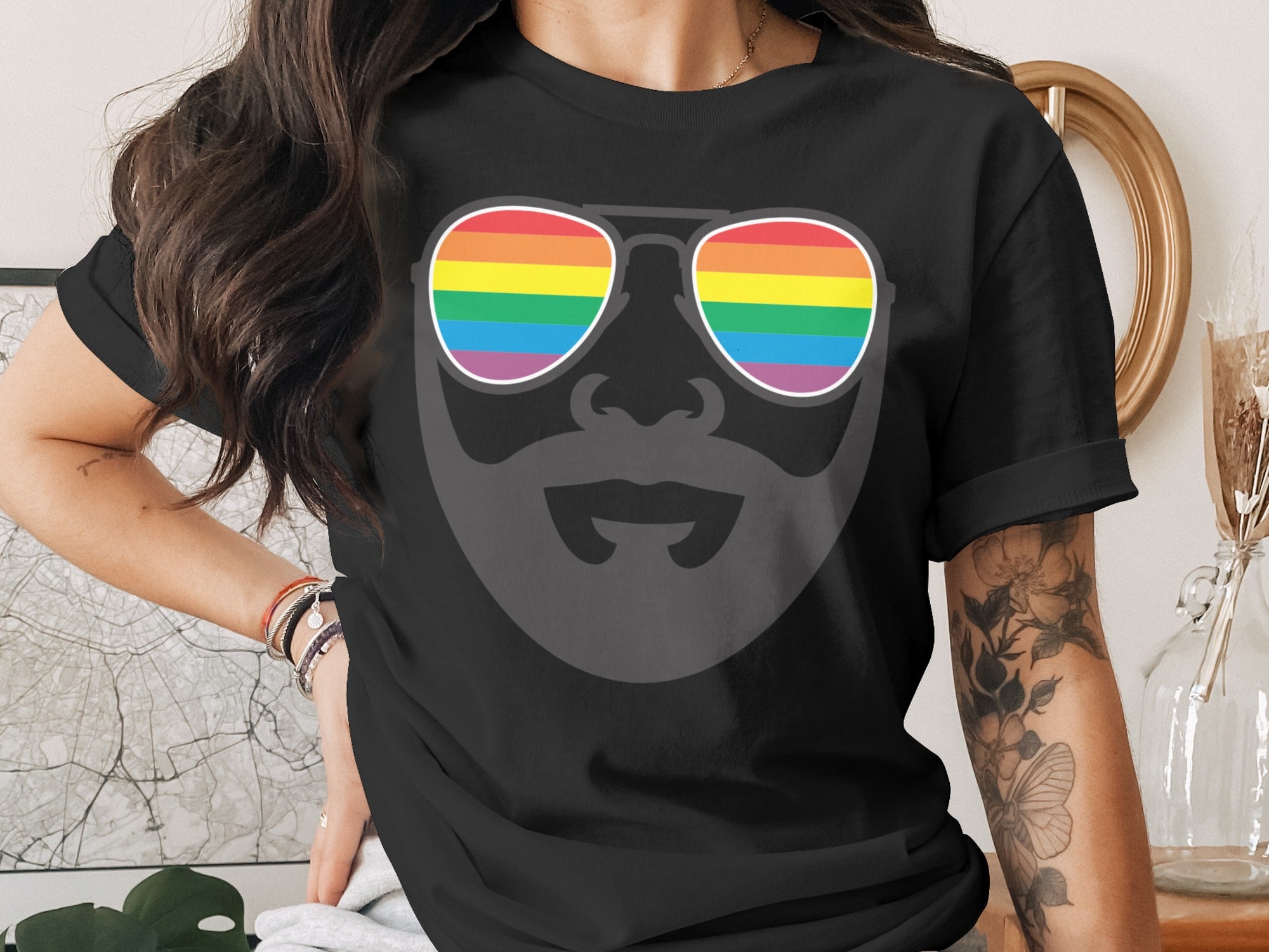 Black t-shirt with a graphic of a face wearing rainbow-striped aviator sunglasses.