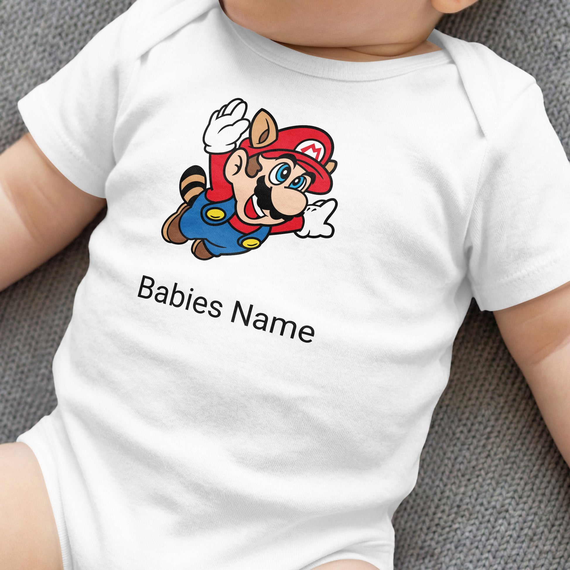 White baby onesie with Mario character and "Babies Name" text.