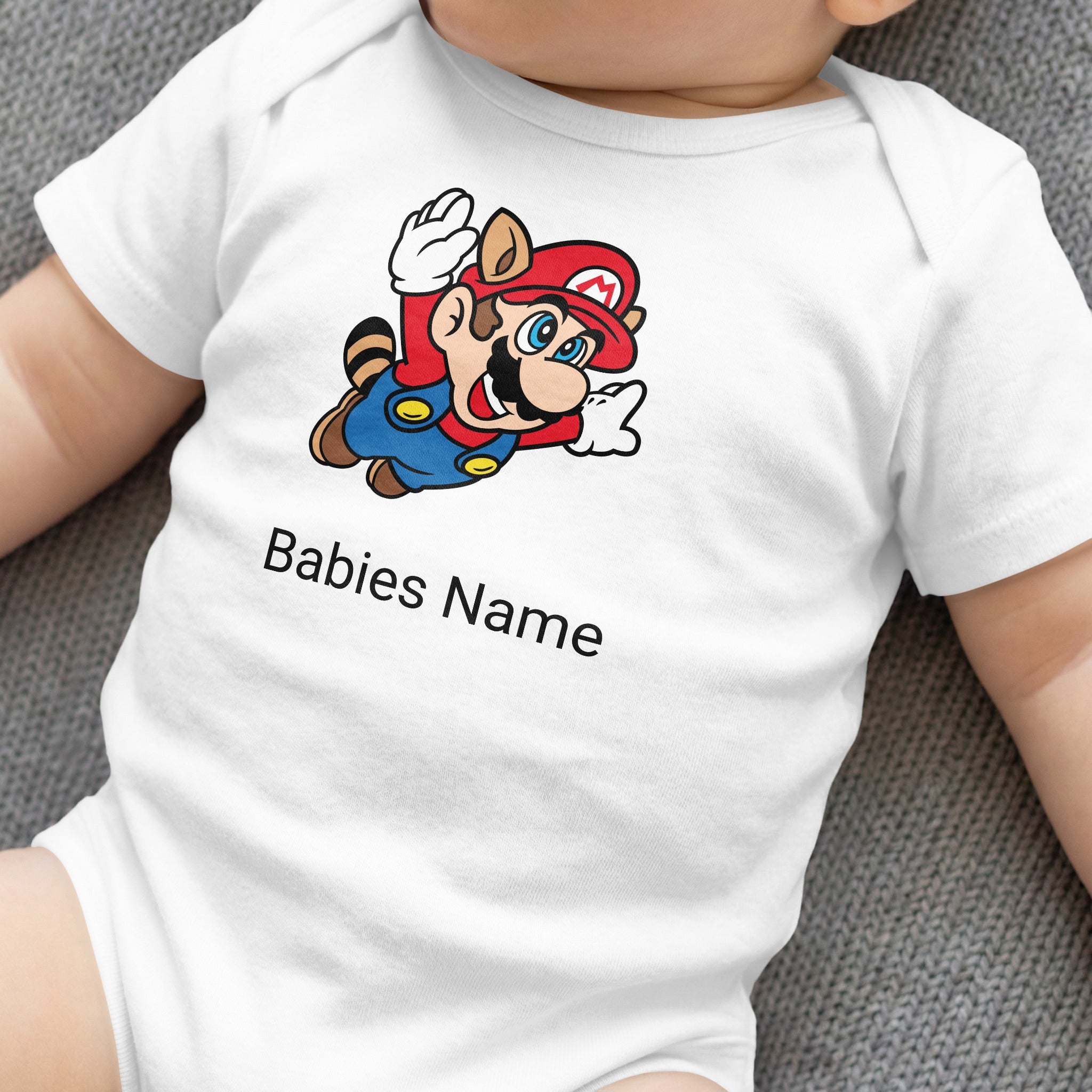White baby onesie with Mario character and "Babies Name" text.