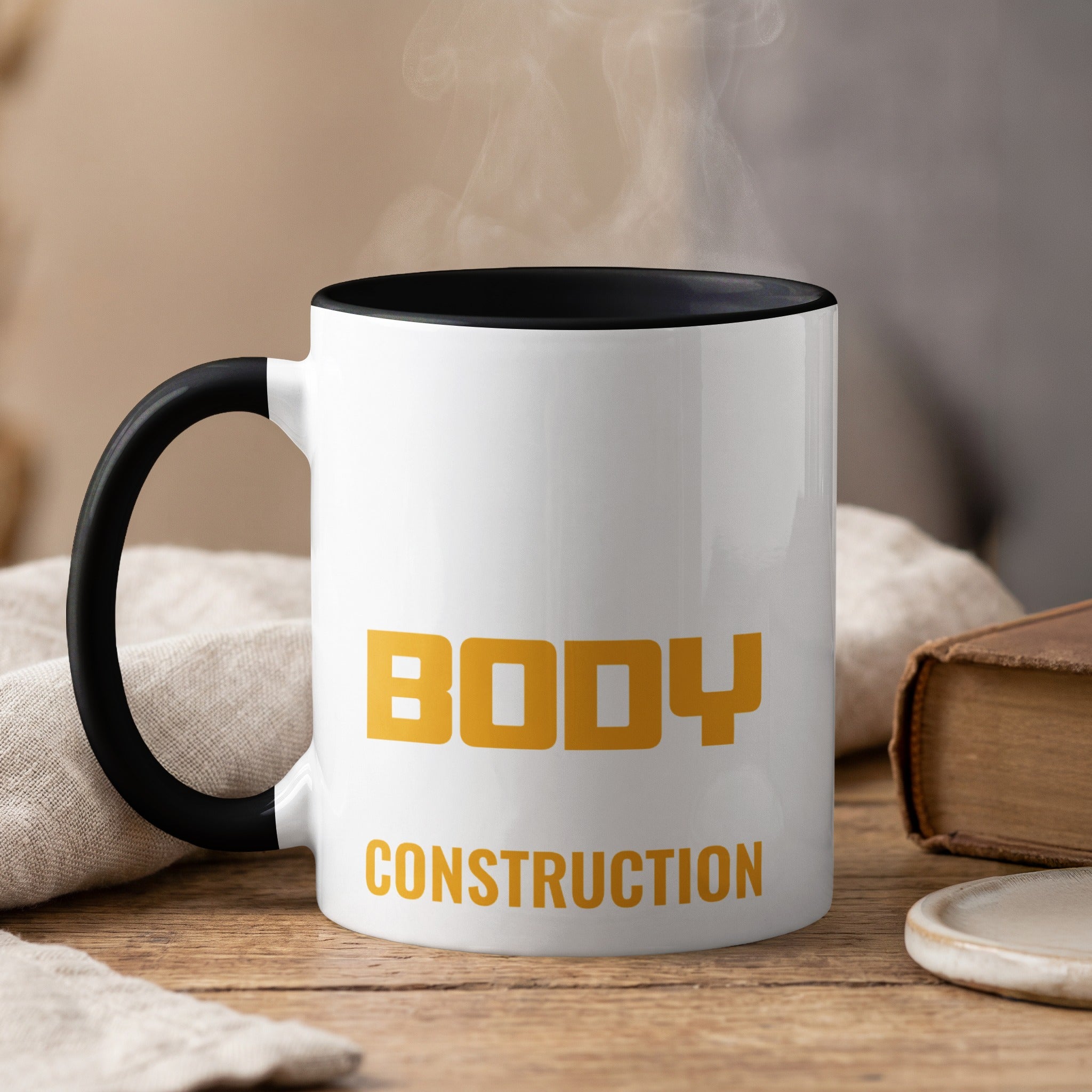 White mug with black rim, steam rising, says "BODY CONSTRUCTION" in yellow.
