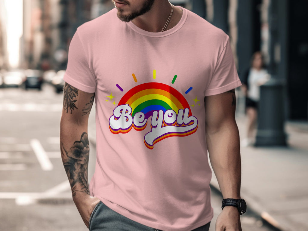 Pink t-shirt with rainbow arc graphic and "Be you" text.