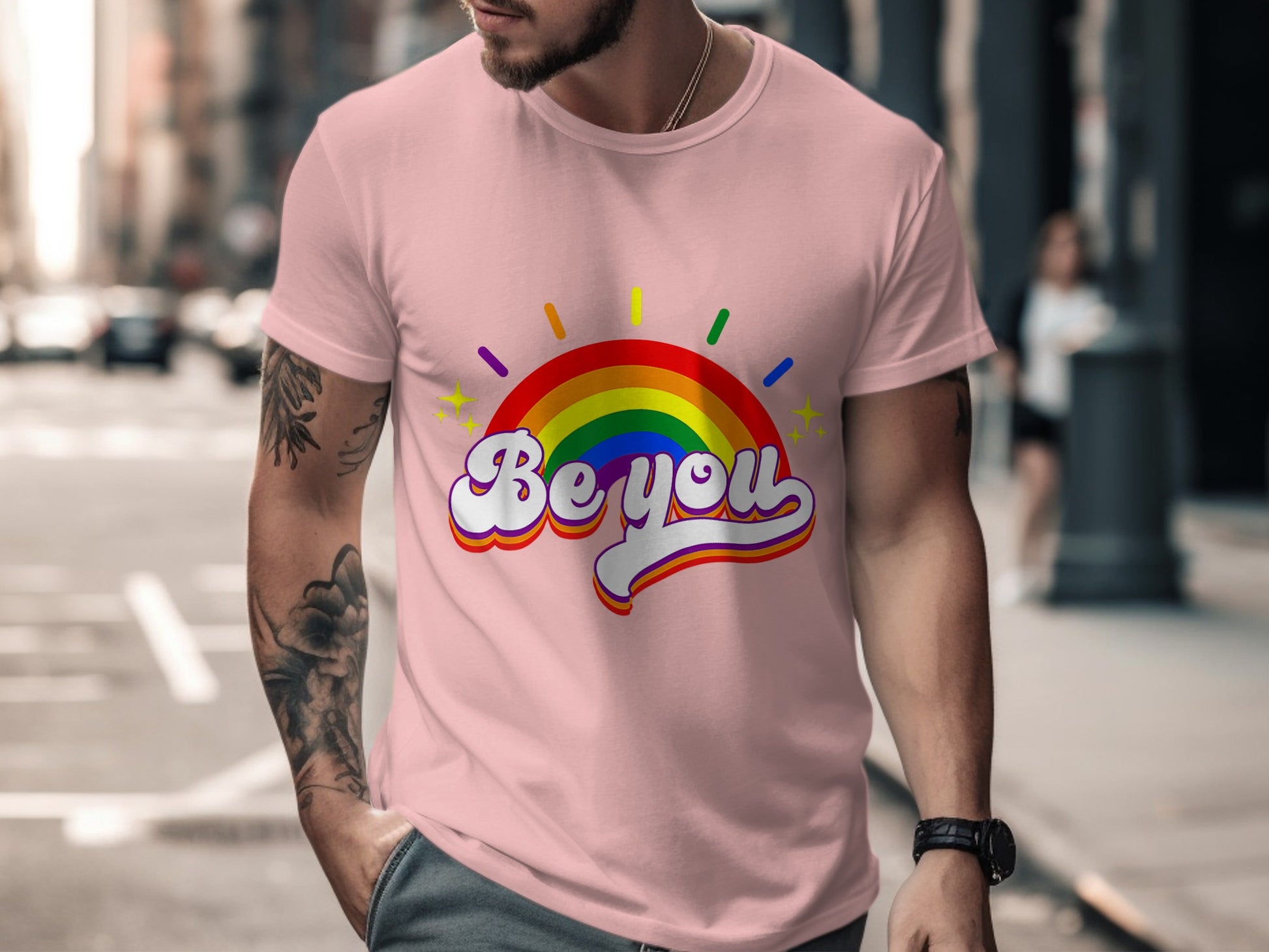 Pink t-shirt with rainbow arc graphic and "Be you" text.