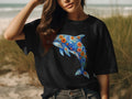 Black t-shirt with a blue dolphin adorned with orange and blue flowers.