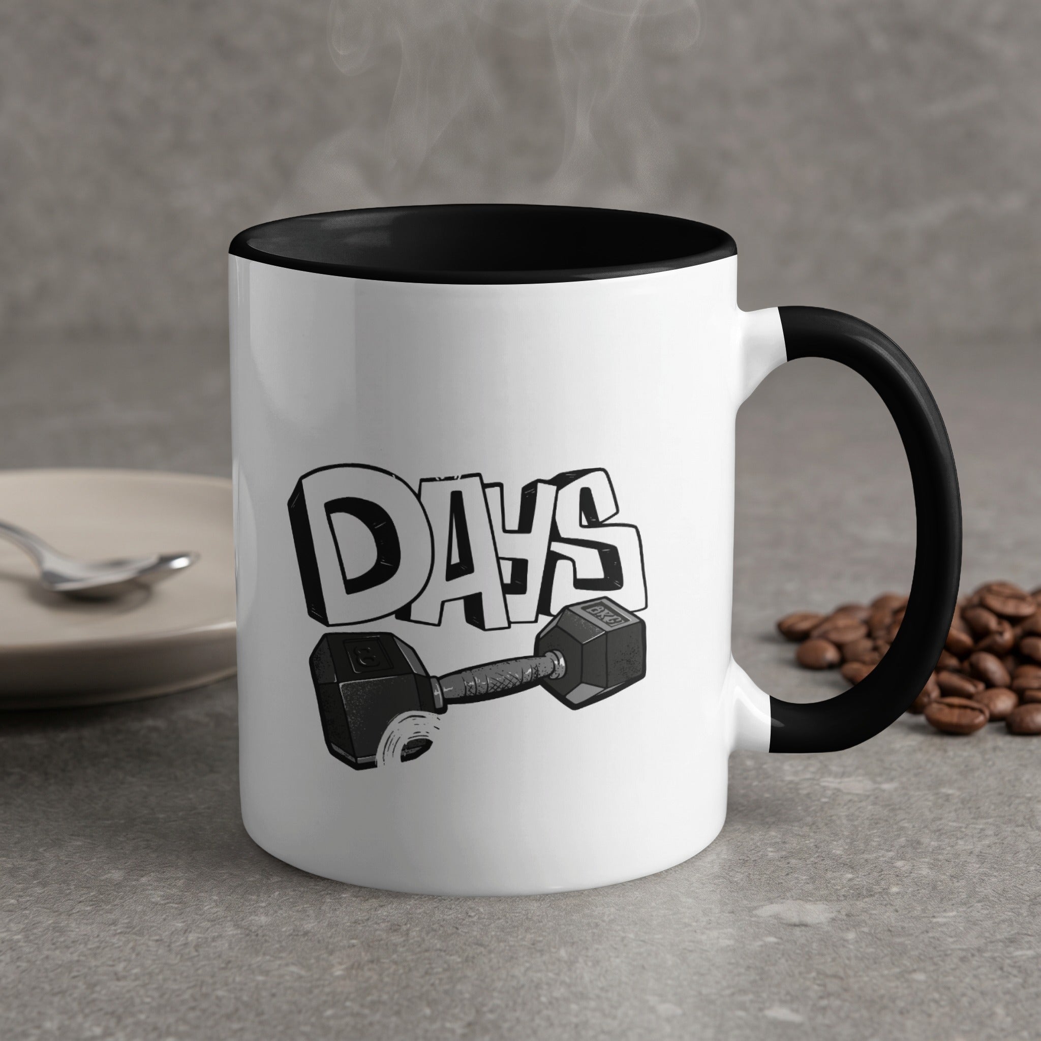 White mug with black rim, "DAYS" text and dumbbell graphic, coffee beans.