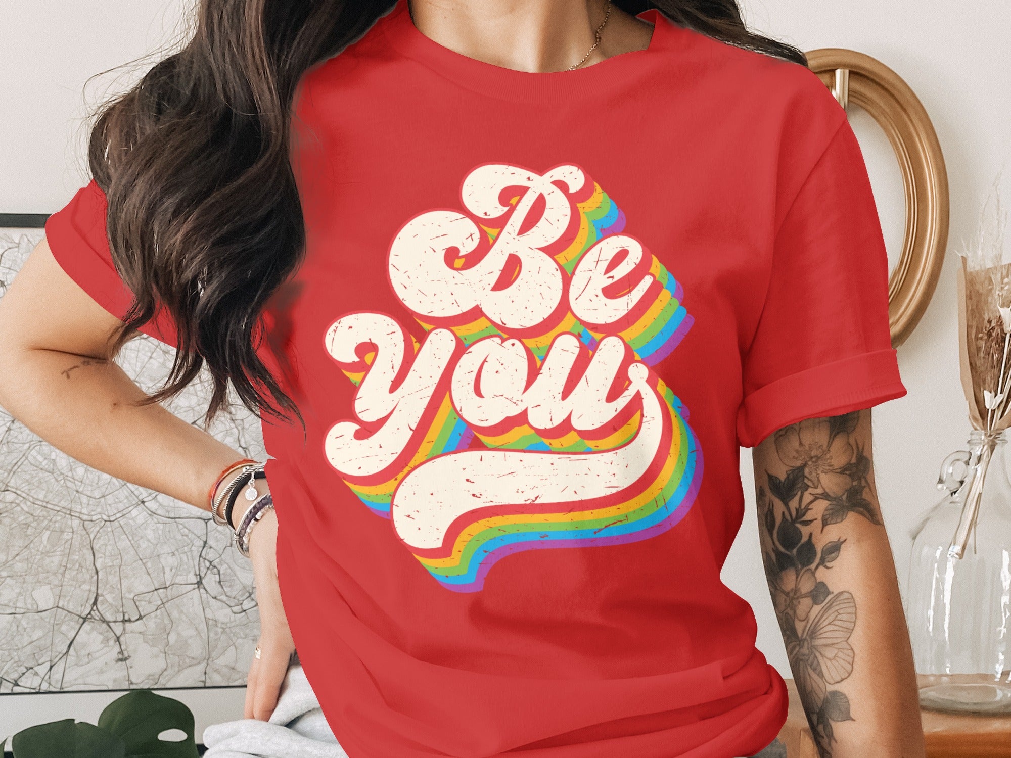 Red t-shirt with distressed "Be You" text in a retro rainbow font.