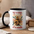 Mug with muscular man and motivational text "Set a goal that makes you want to jump out of bed in the morning."