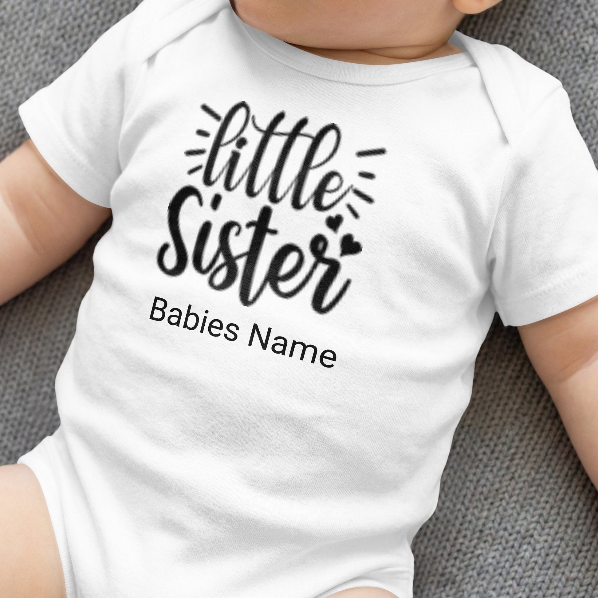 White baby onesie with "little Sister" and "Babies Name" text.