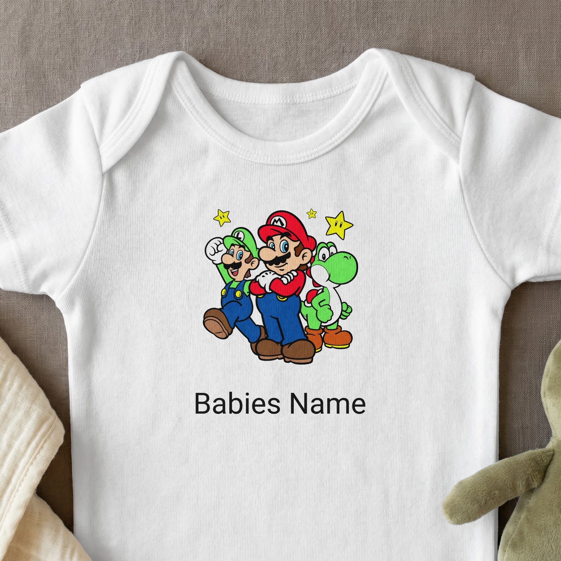 Mario, Luigi, and Yoshi characters embroidered on a white baby onesie.