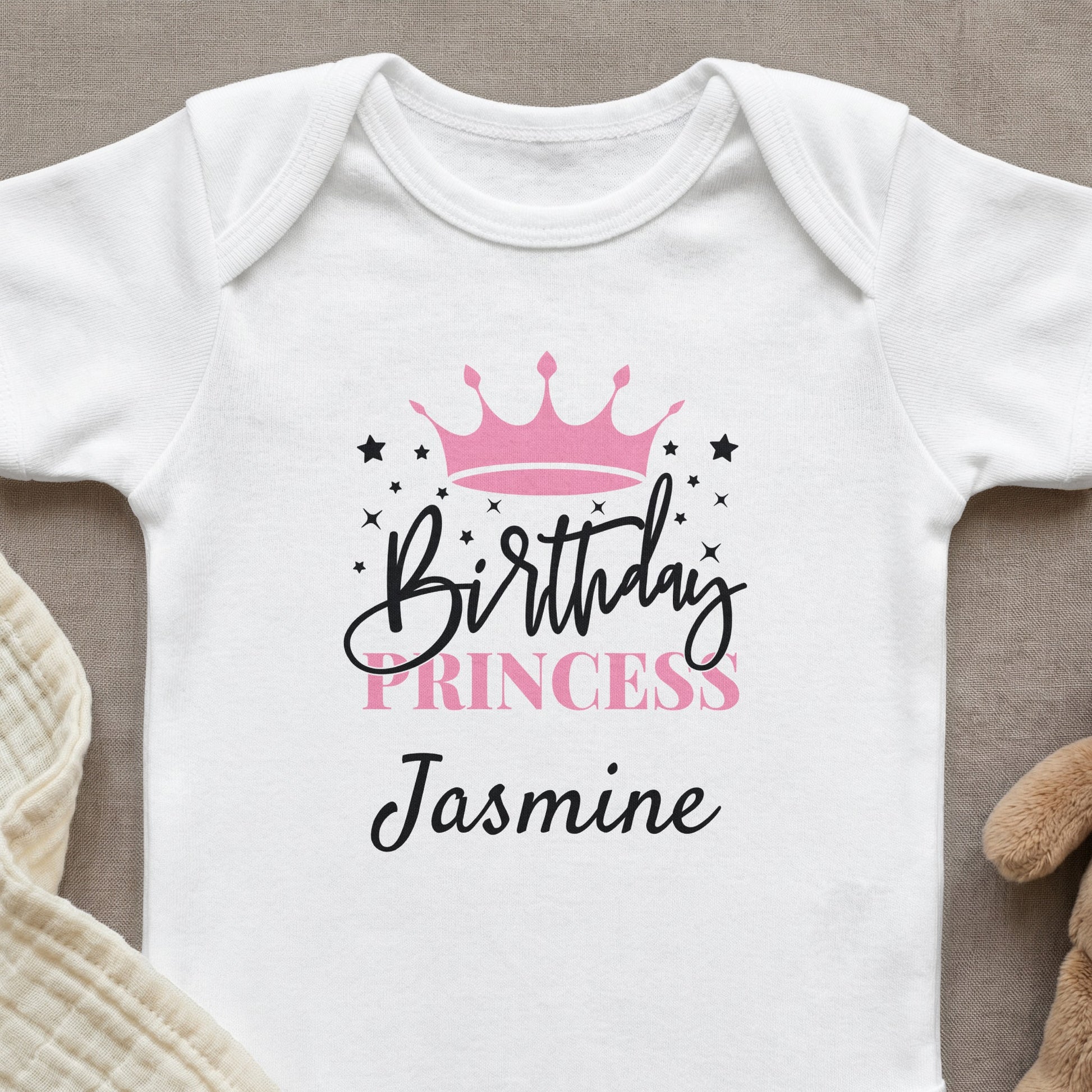 White baby onesie with "Birthday Princess Jasmine" and a crown graphic.