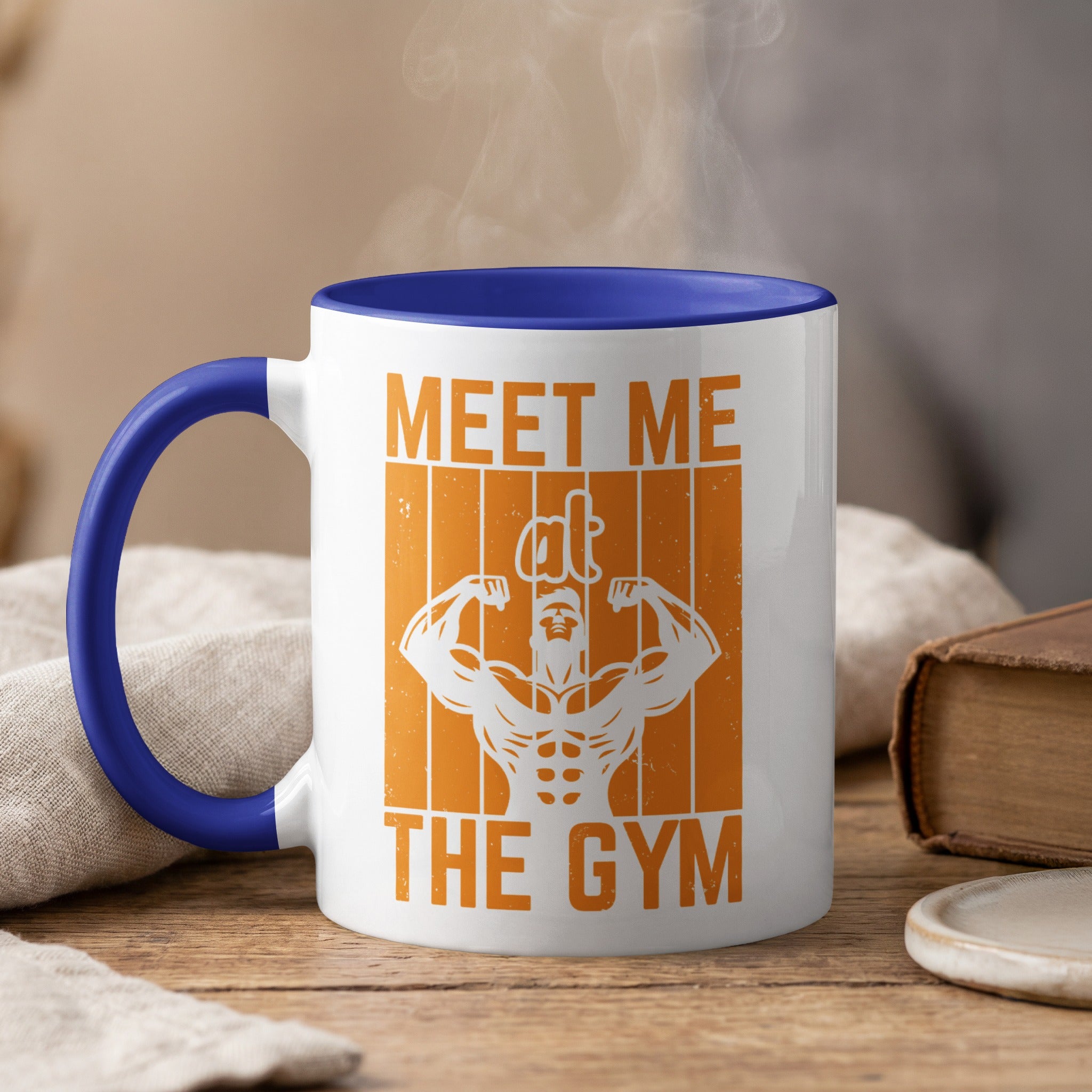 White mug with blue rim, featuring orange graphic and text "MEET ME THE GYM".