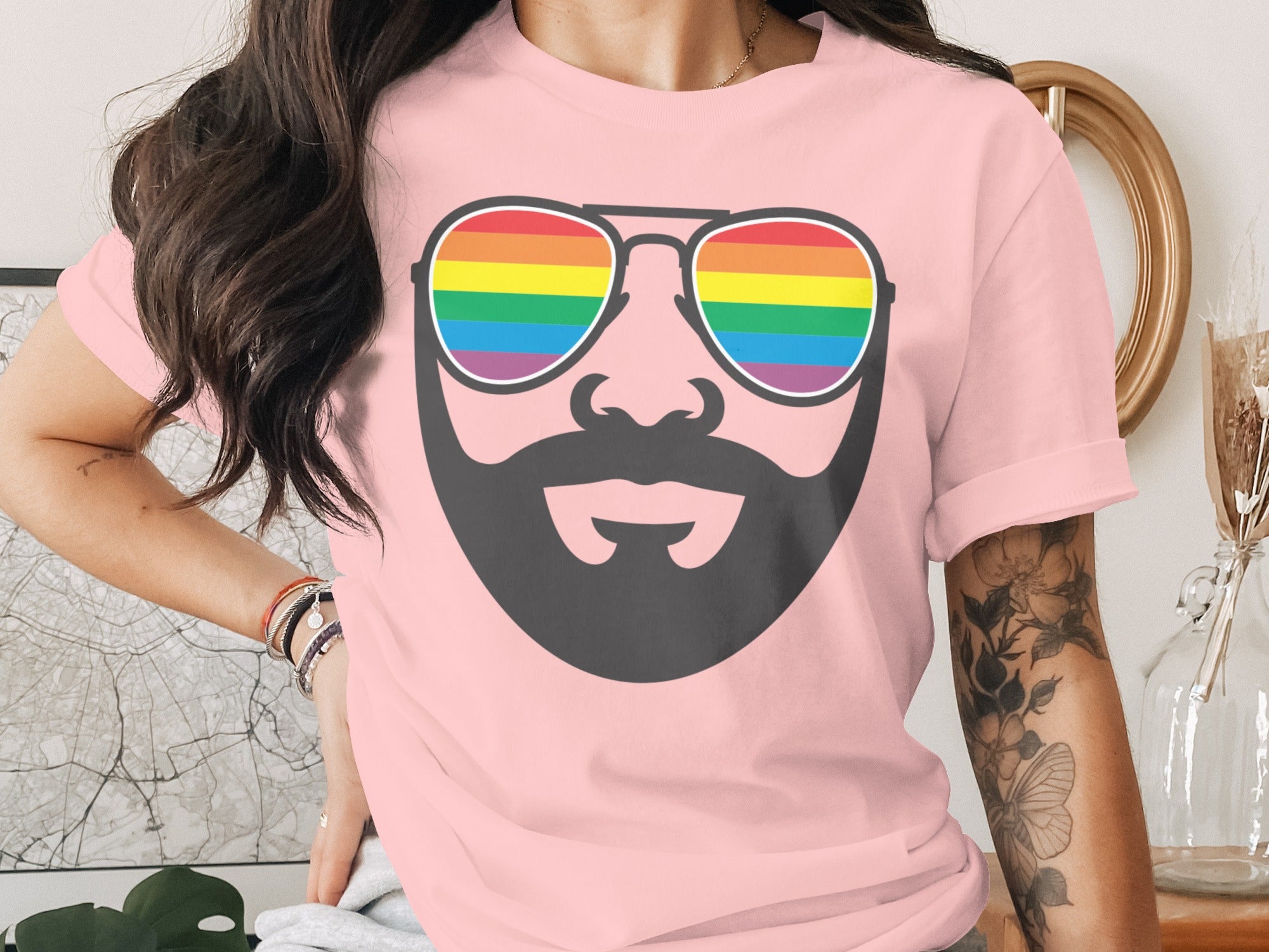 Pink t-shirt with a stylized charcoal beard and rainbow sunglasses graphic.