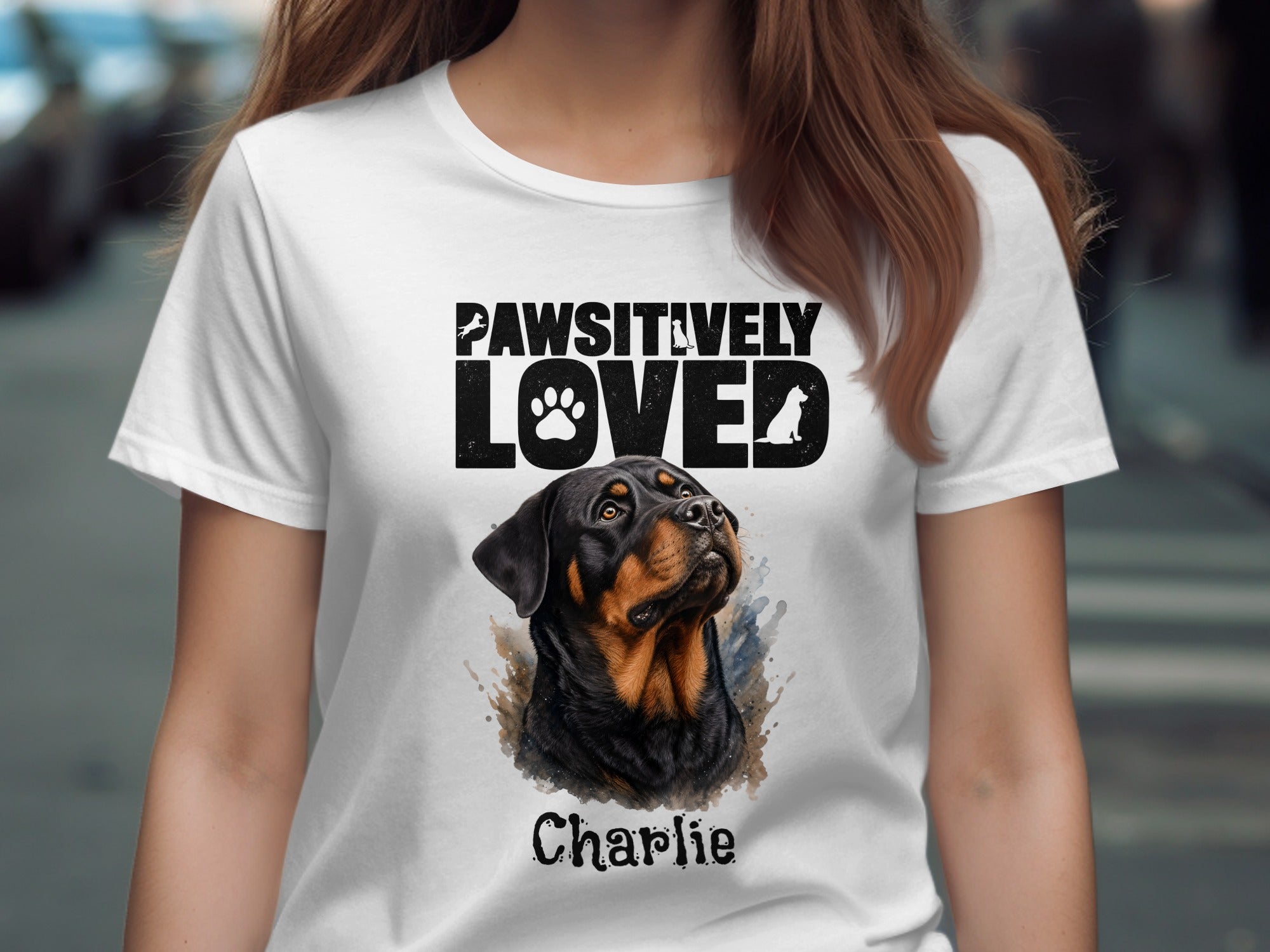 White t-shirt with "PAWSITIVELY LOVED" and a Rottweiler named Charlie.