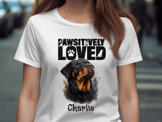 White t-shirt with "PAWSITIVELY LOVED" and a Rottweiler named Charlie.