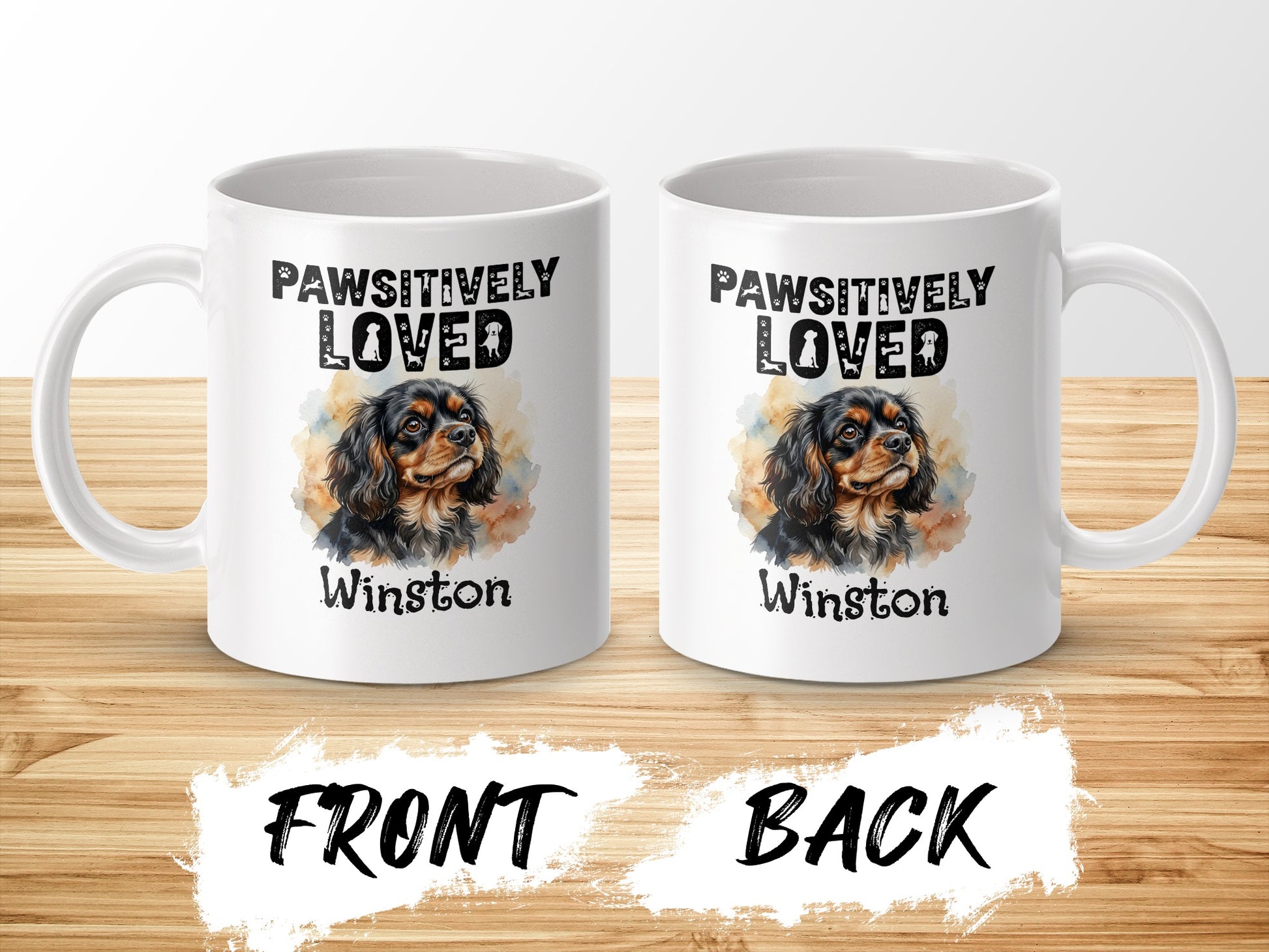 Two white mugs displaying a watercolor portrait of a Cavalier King Charles Spaniel named Winston.