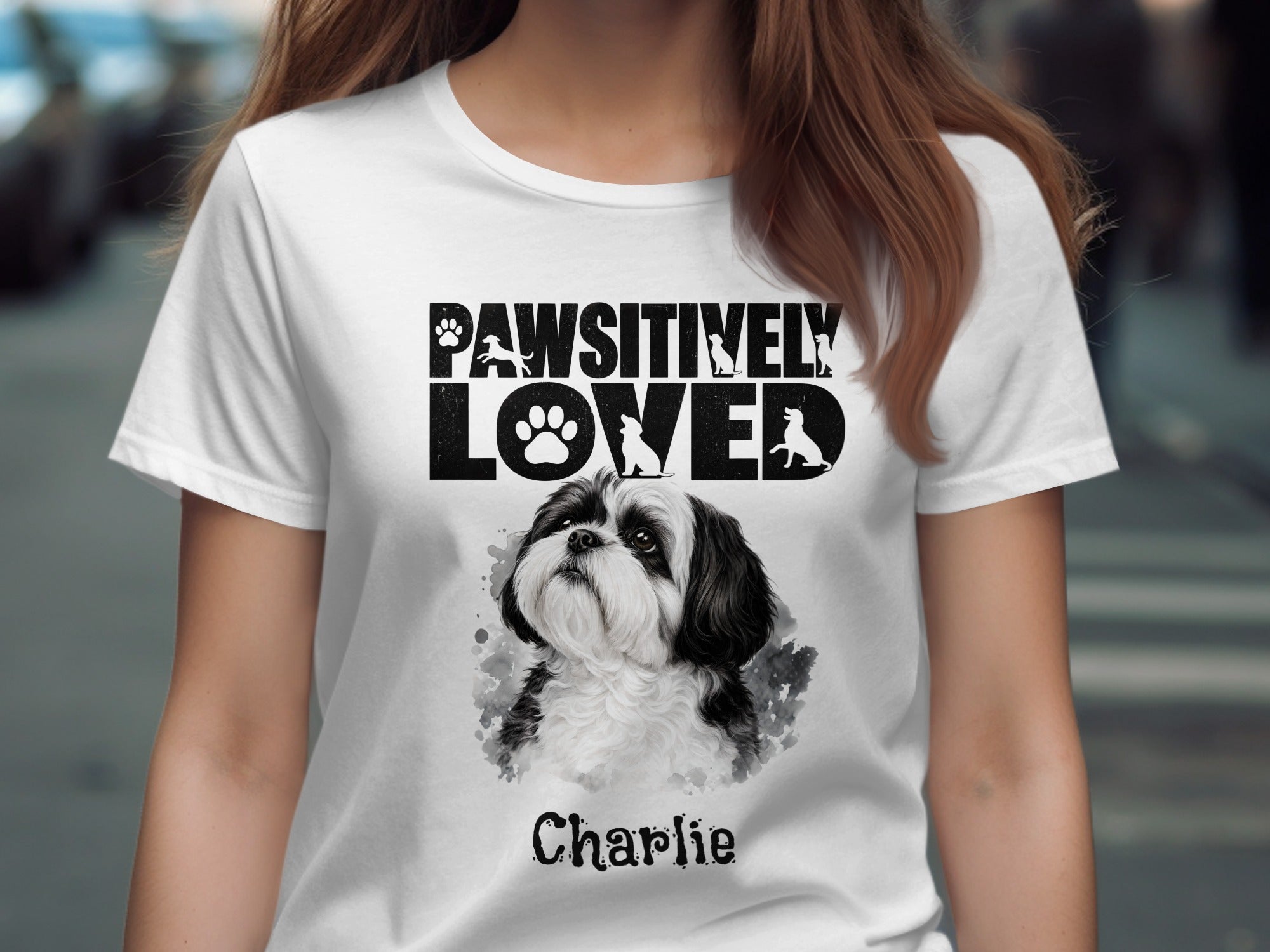 White t-shirt with "PAWSITIVELY LOVED" text, dog silhouettes, and a Shih Tzu named Charlie.