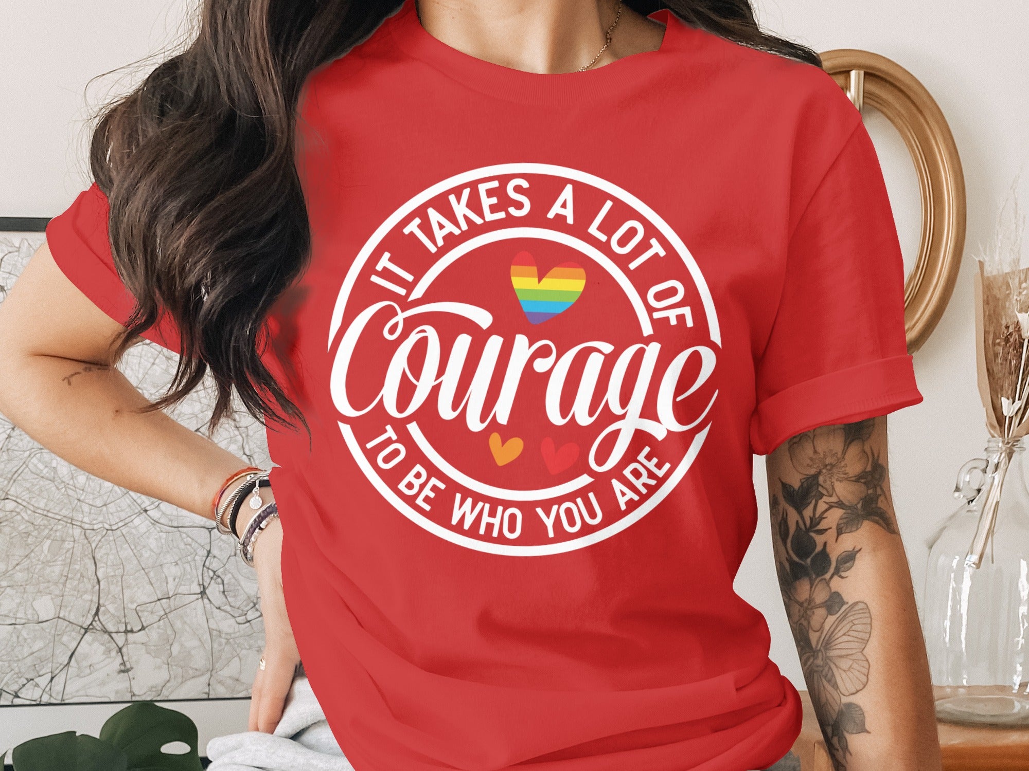 Red t-shirt with white text "It Takes A Lot of Courage To Be Who You Are" and rainbow heart.