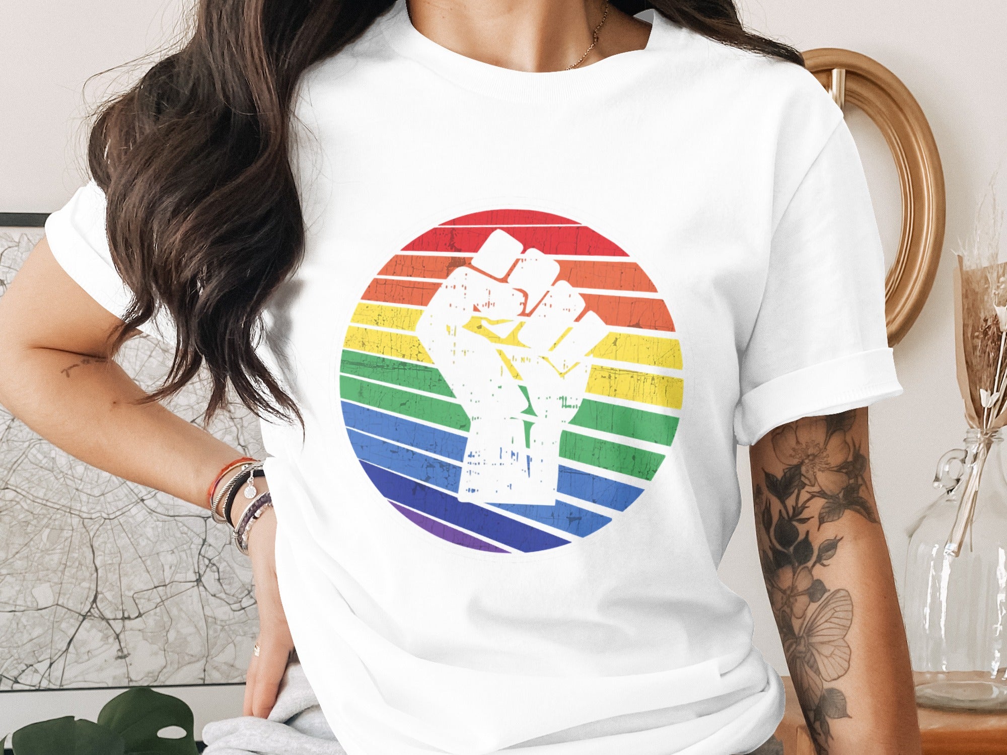 White t-shirt with a raised fist inside a rainbow circle graphic.