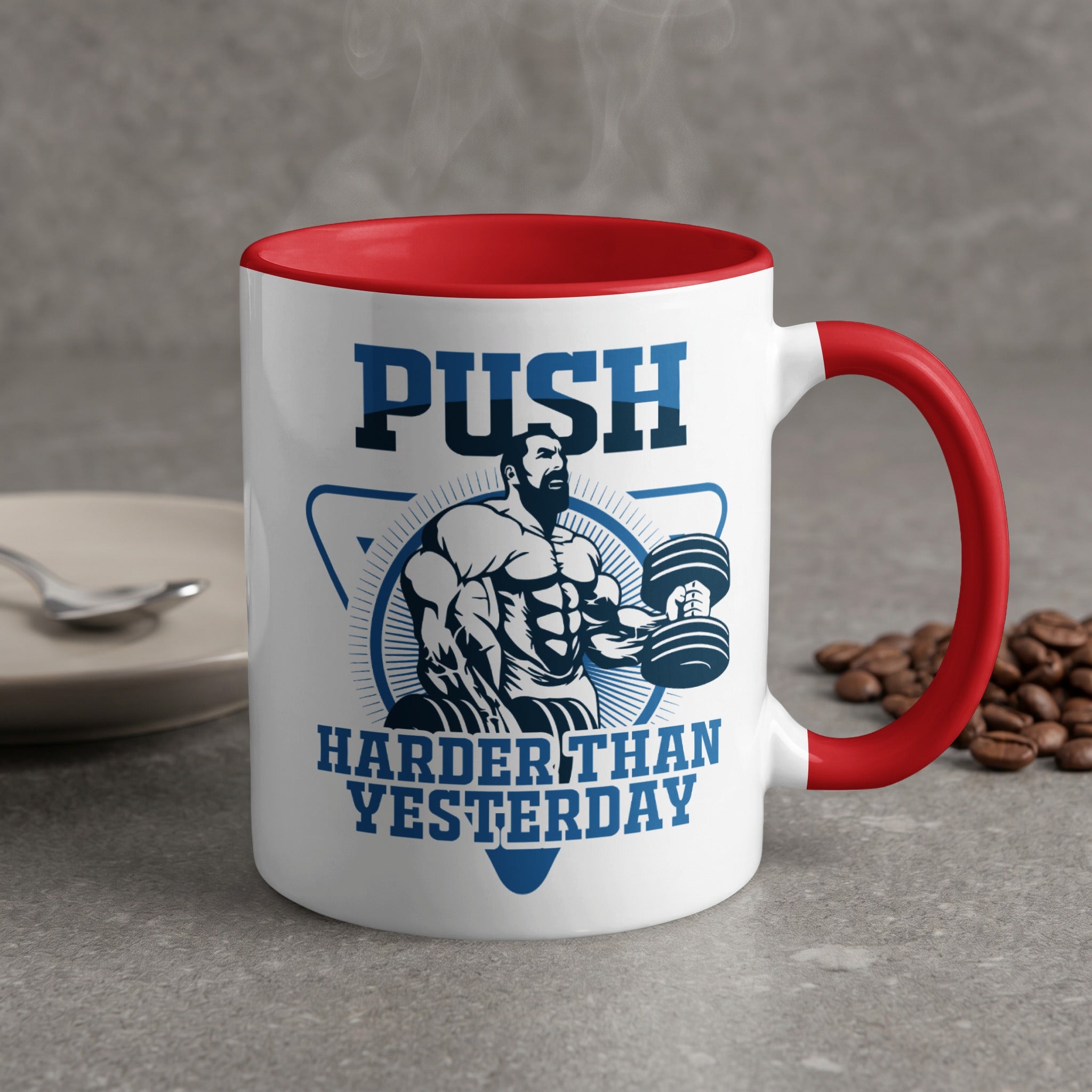 White mug with red rim and handle, featuring muscular man lifting weights and text "PUSH HARDER THAN YESTERDAY".