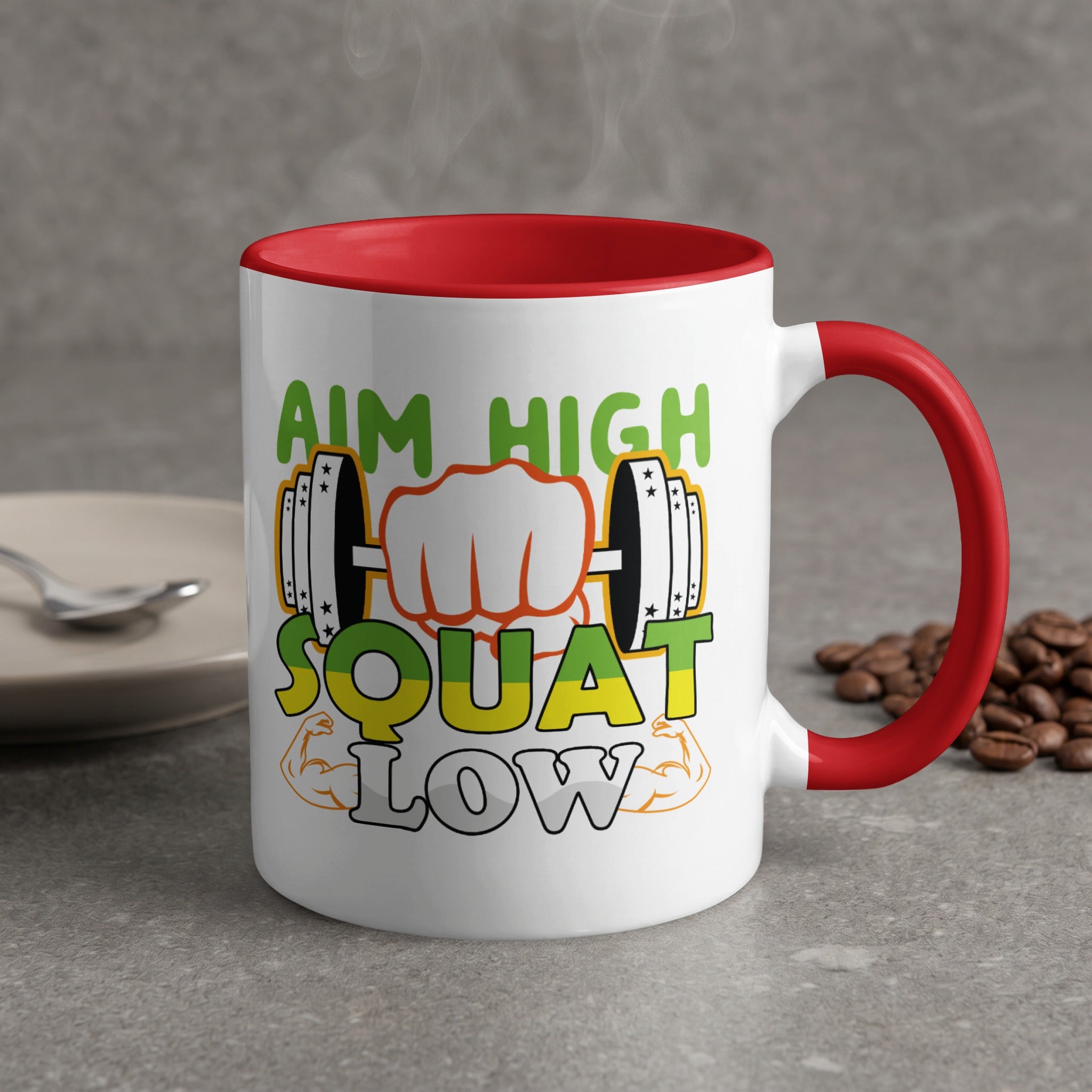White mug with red handle, "Aim High Squat Low" text and dumbbell graphic.