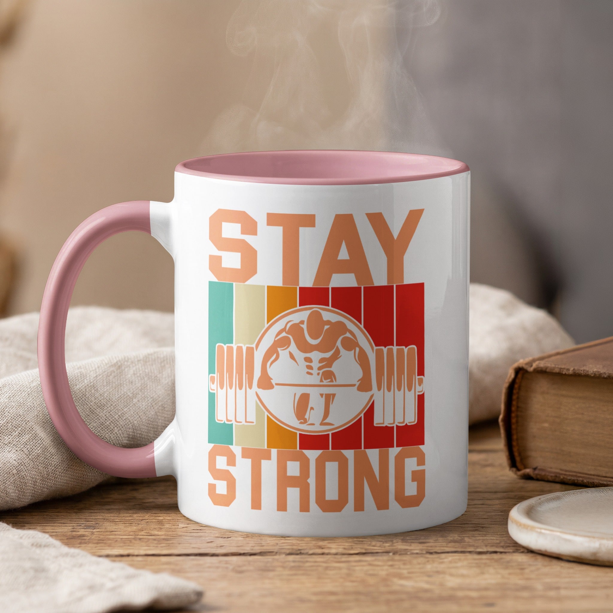 White mug with pink handle, "Stay Strong" text, and barbell graphic.