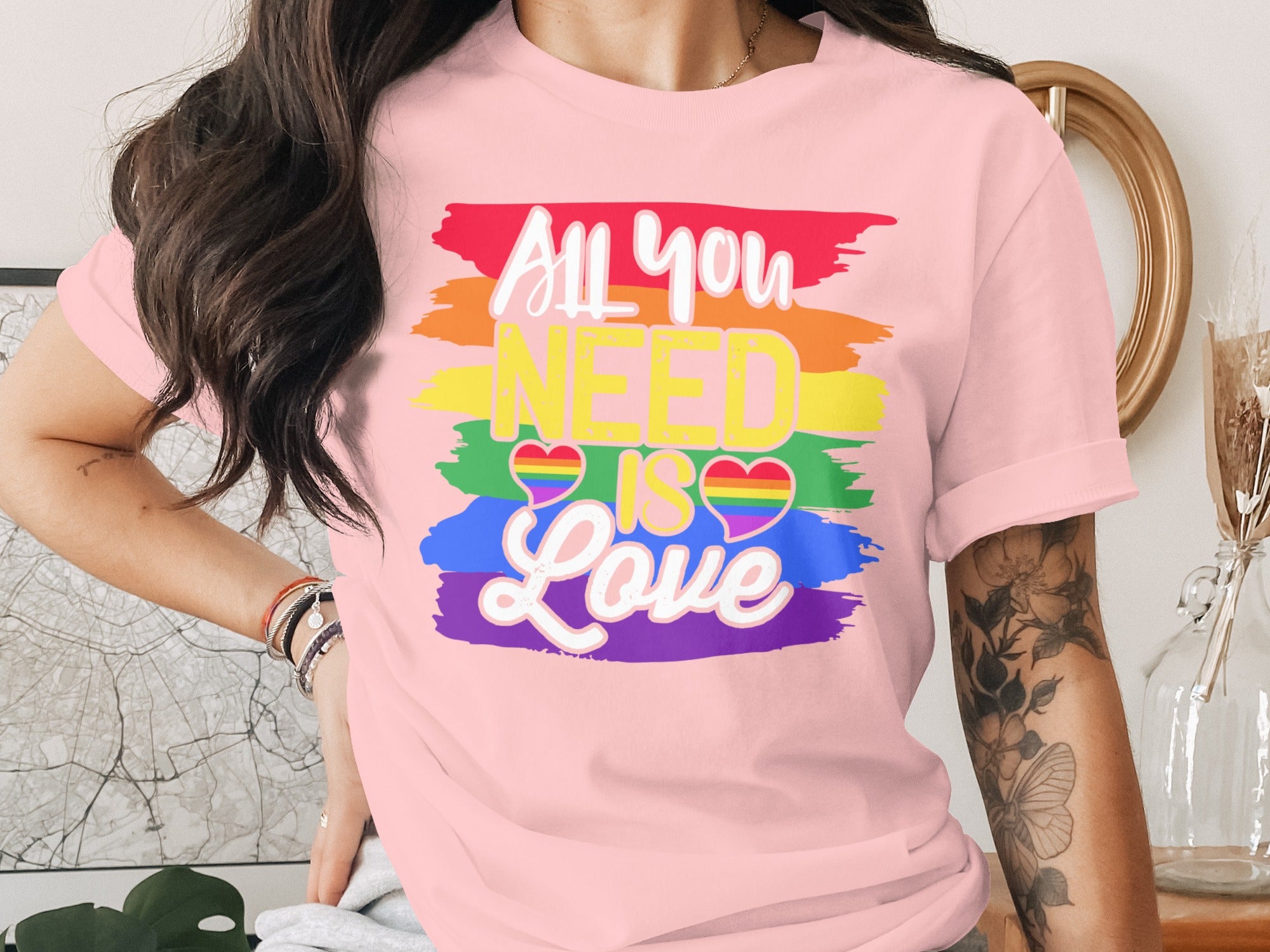 Pink t-shirt with rainbow stripes and "All you NEED IS Love" text.