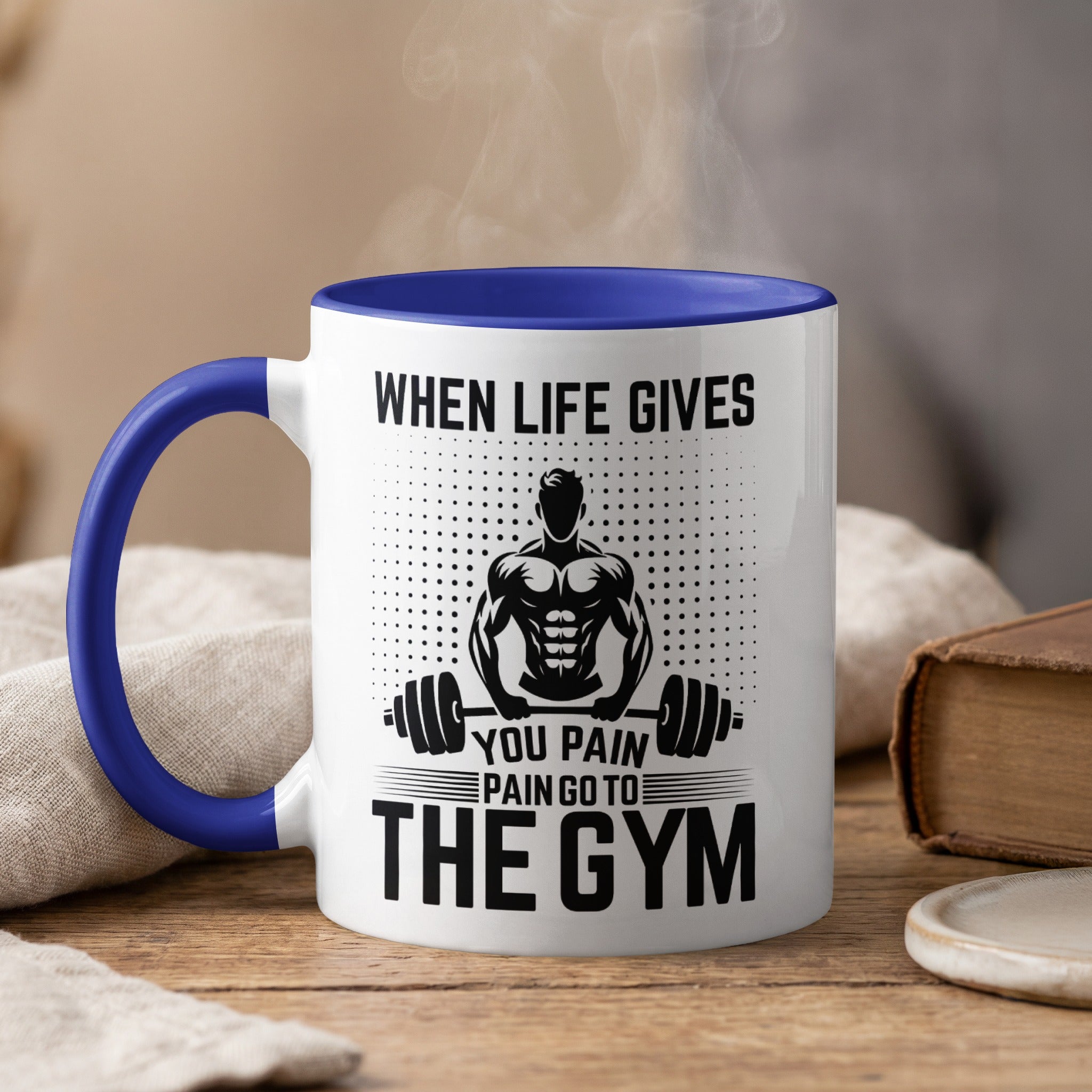 White mug with blue rim and handle, features text and muscular man graphic.