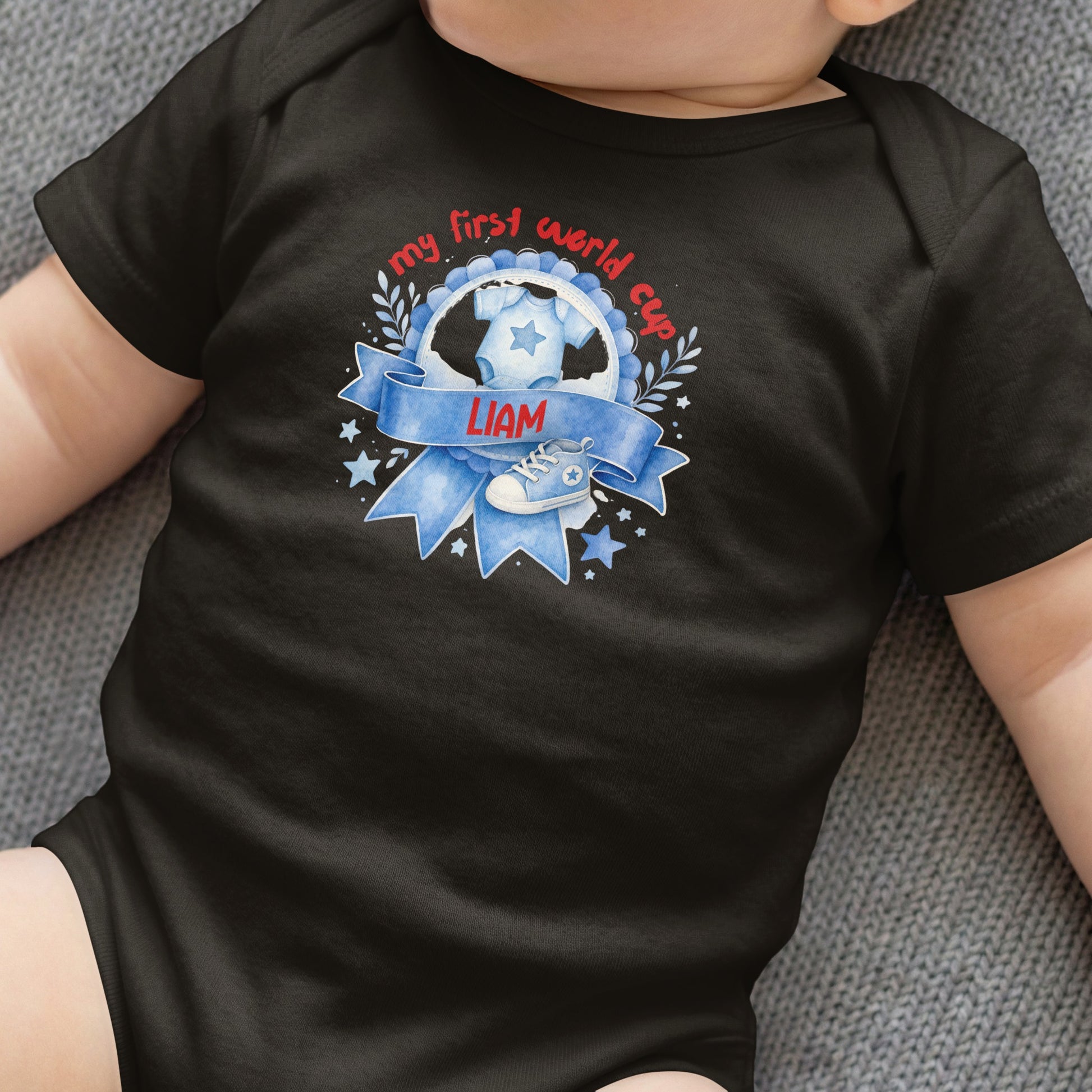 Black baby onesie with "my first world cup" text and a soccer shoe.