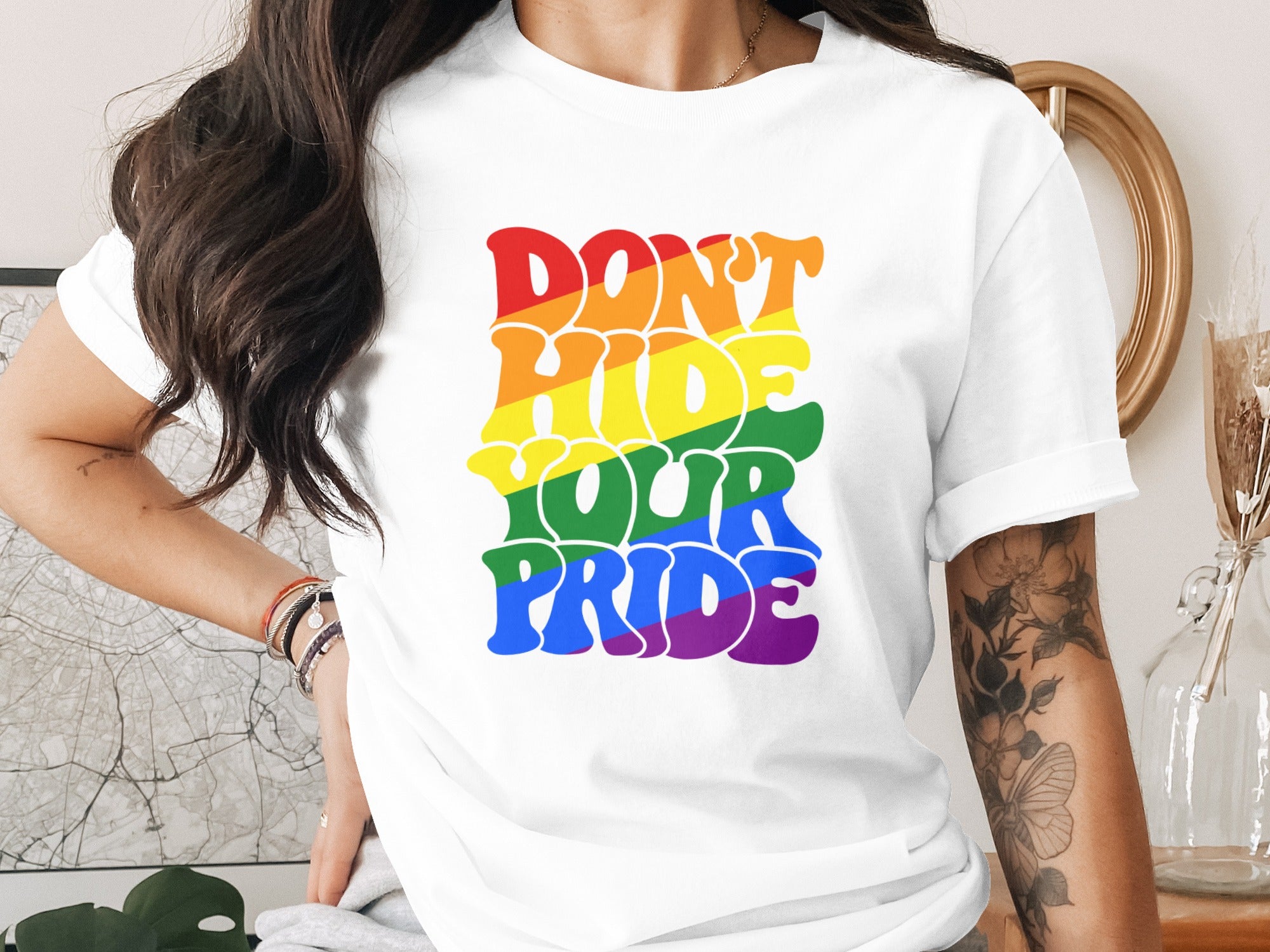 White t-shirt with rainbow text that says "Don't Hide Your Pride."