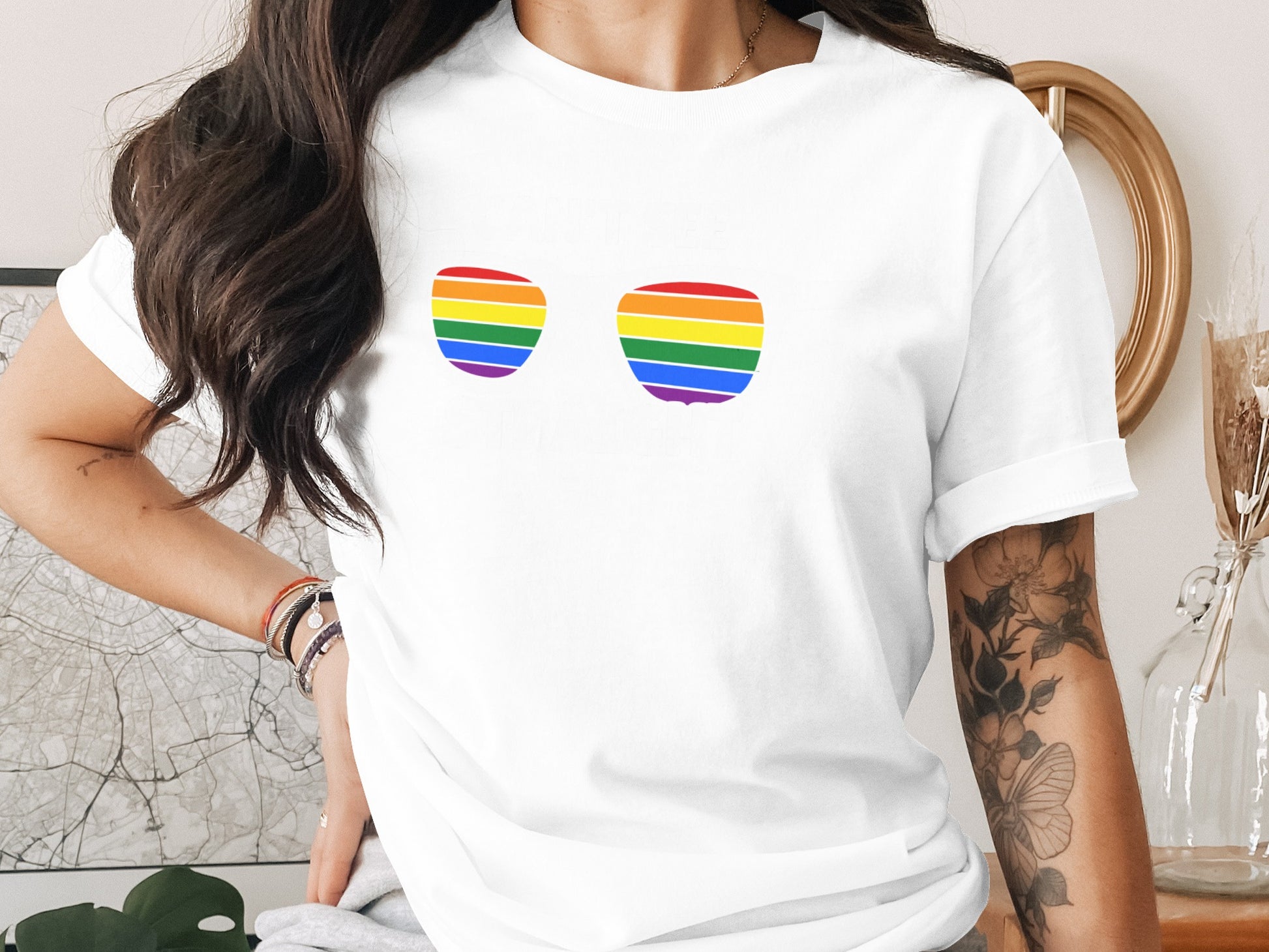 White t-shirt with two rainbow-striped sunglass shapes on the chest.