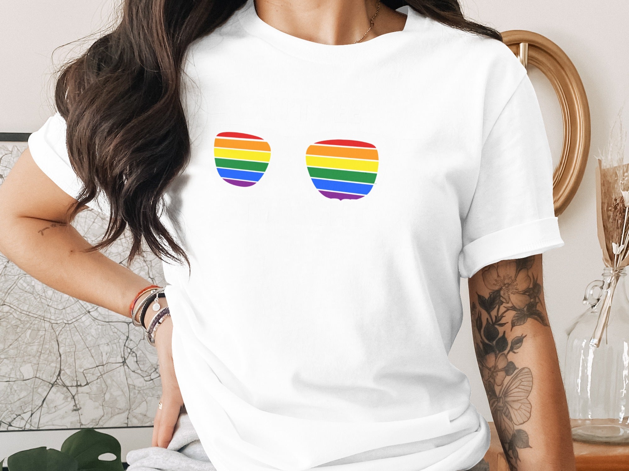White t-shirt with two rainbow-striped sunglass shapes on the chest.